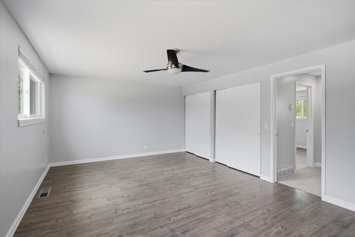 Spacious interior featuring wood-finish flooring, light gray wall paint, and white trim
