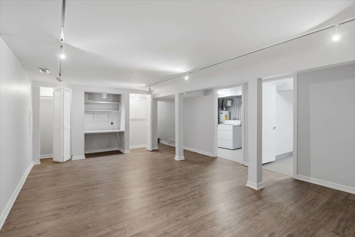 Spacious lower-level area featuring wood-finish flooring, recessed lighting, and track lighting