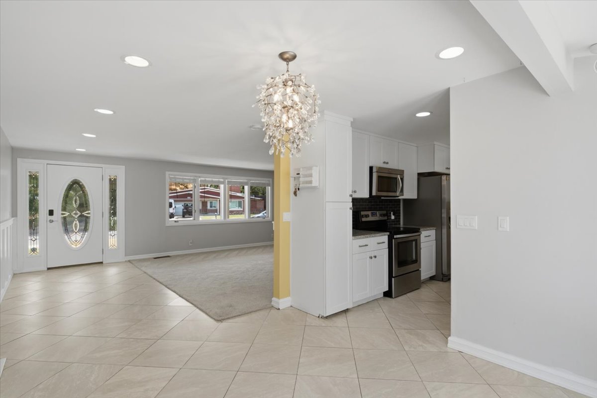 Tiled entryway with a decorative glass front door and sidelights
