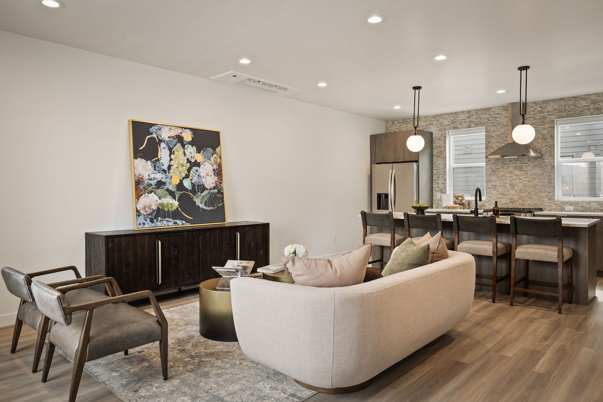 Open-concept living space featuring wood-finish flooring, recessed lighting, and a modern kitchen