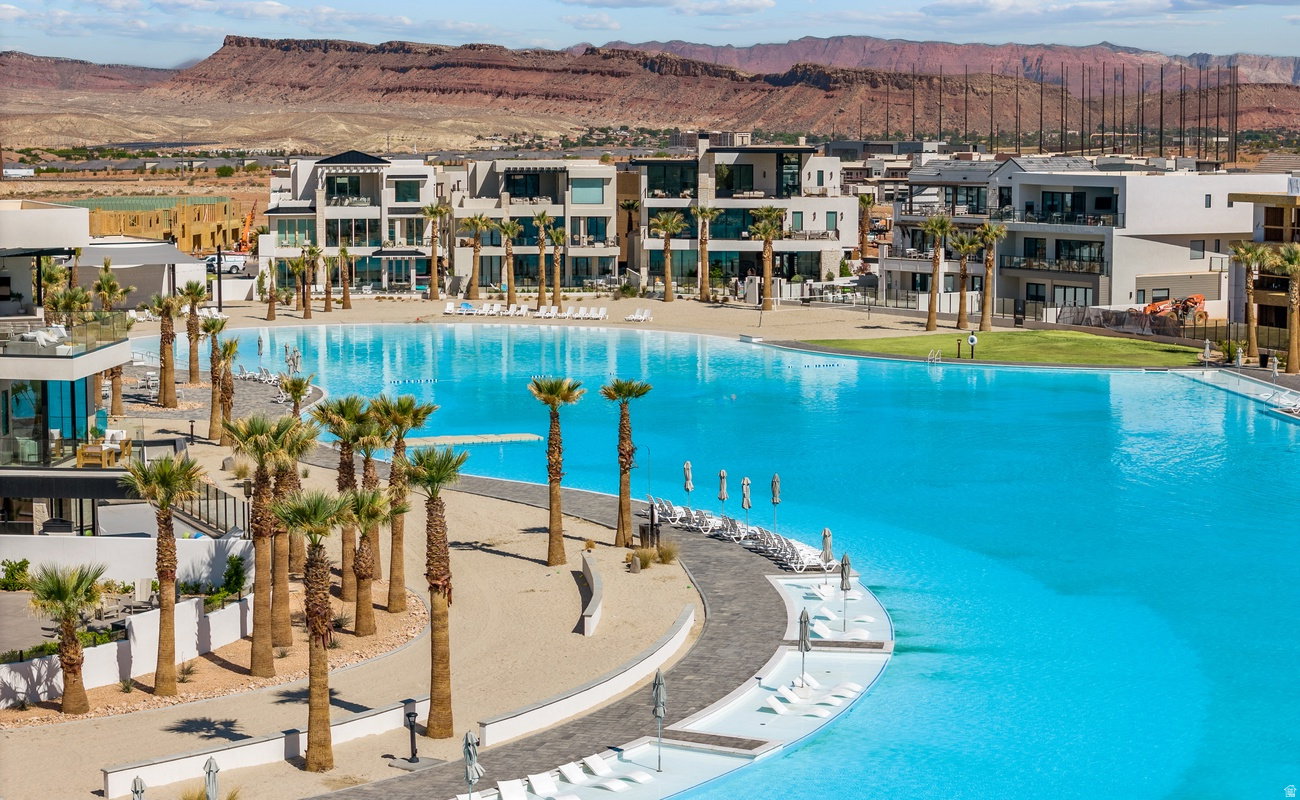 Expansive blue lagoon bordered by sandy areas and mature palm trees
