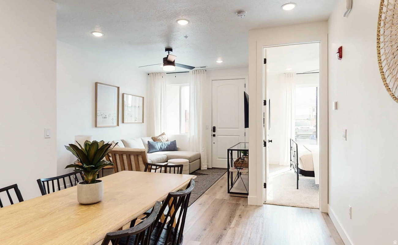 Bright living area with recessed lighting, wood-finish flooring, and a contemporary ceiling fan
