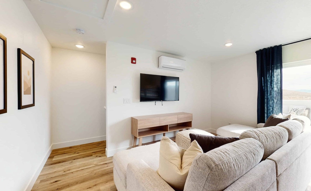 Bright living area with recessed lighting and wood-finish flooring