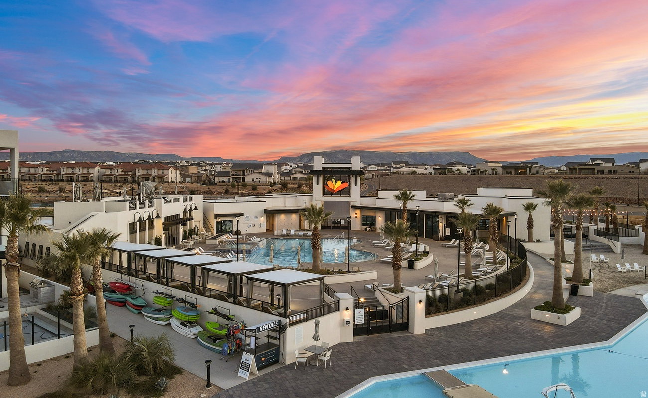 Expansive outdoor recreation area featuring multiple swimming pools, extensive patio decking, and numerous cabanas