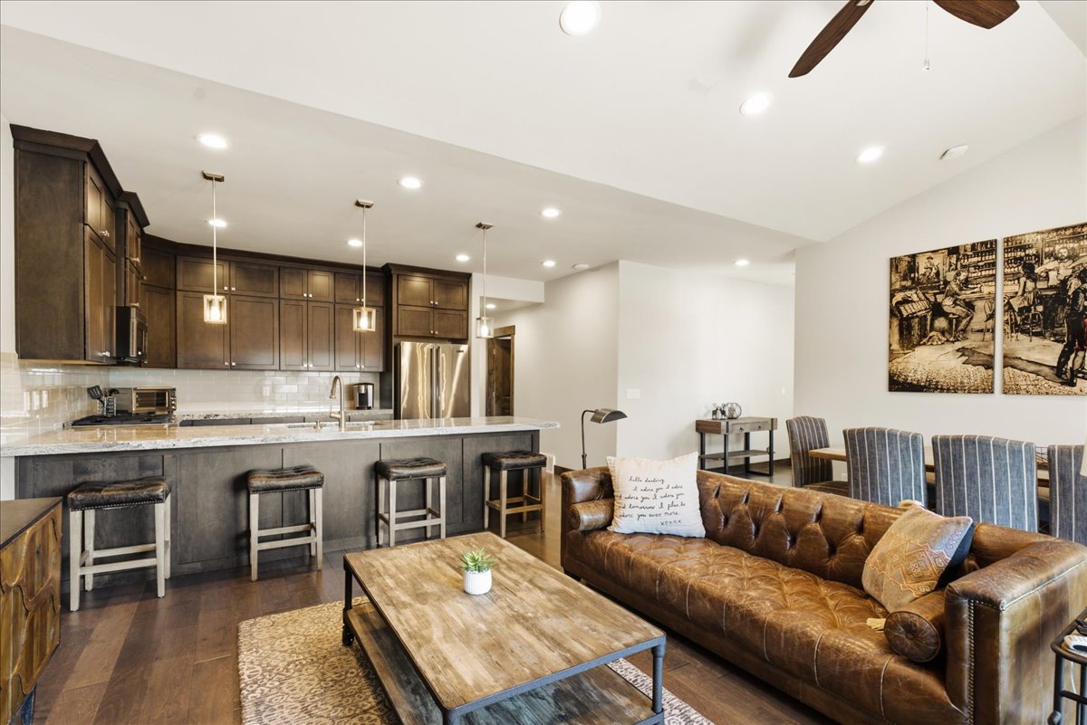 Open-concept living space featuring wood-finish flooring, recessed lighting, and vaulted ceilings