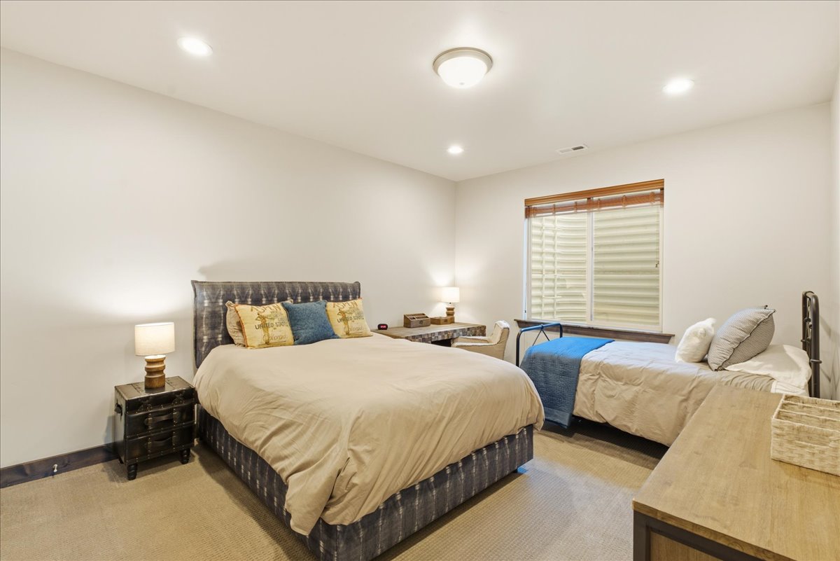 Neutral wall paint, recessed lighting, and a flush mount ceiling fixture illuminate this carpeted room