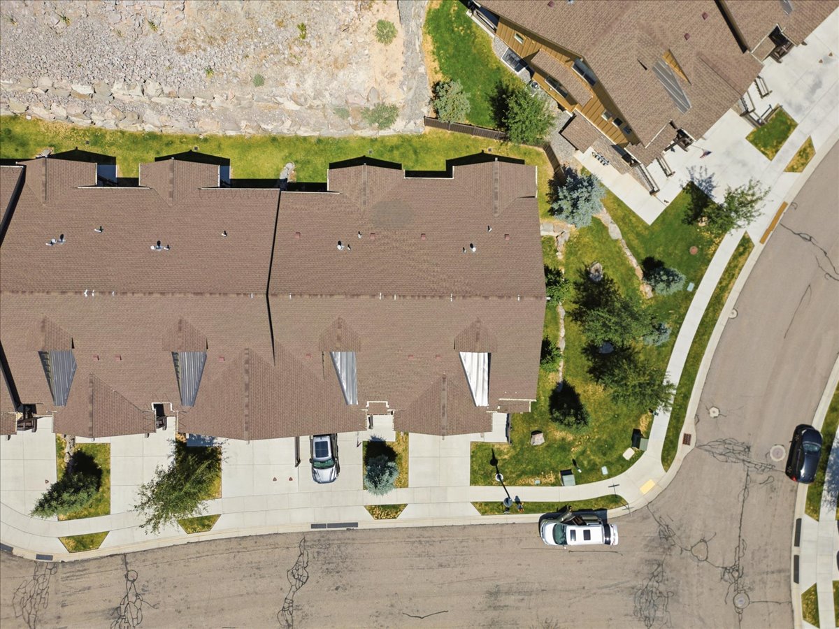 Townhome residences featuring brown shingle roofing and individual driveways
