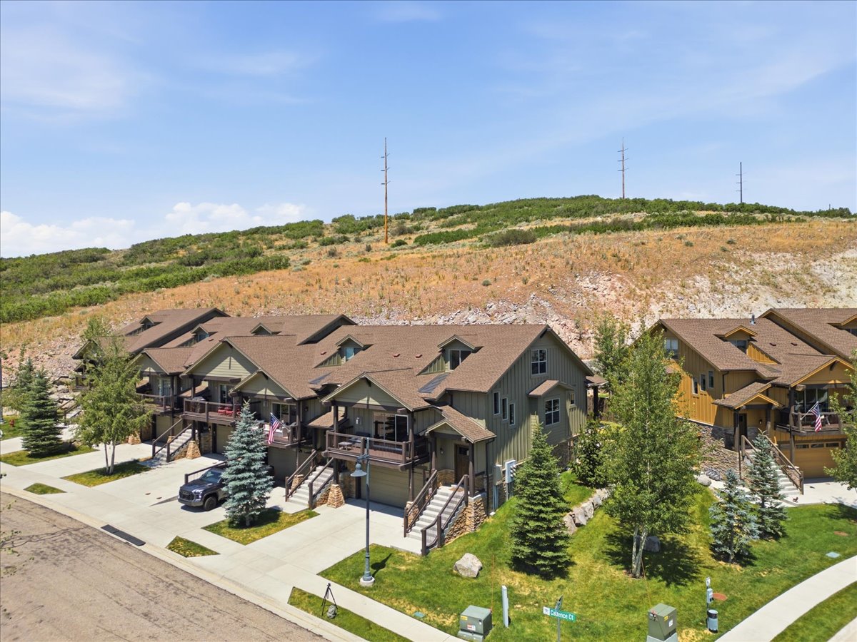 Multi-level townhome-style residences featuring earth-toned siding, attached garages, and private balconies