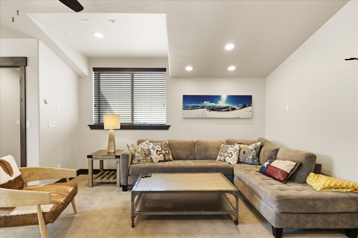 Open-concept living area featuring recessed lighting, a ceiling fan, and a window with horizontal blinds