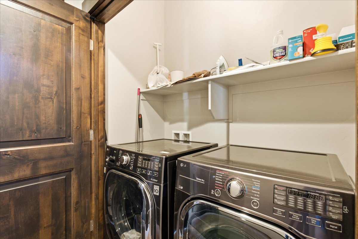 Dedicated laundry area featuring a built-in shelving unit and dark wood-paneled door frame