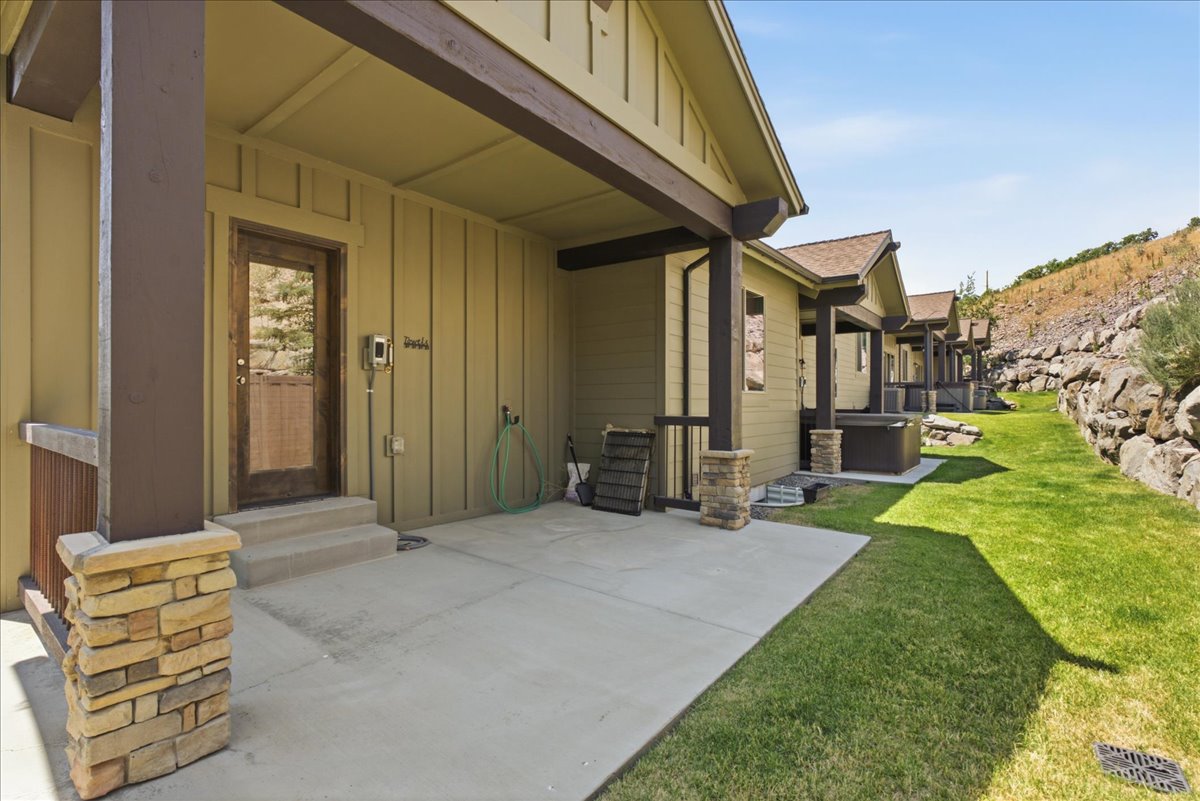 Expansive concrete rear patio area with board and batten siding