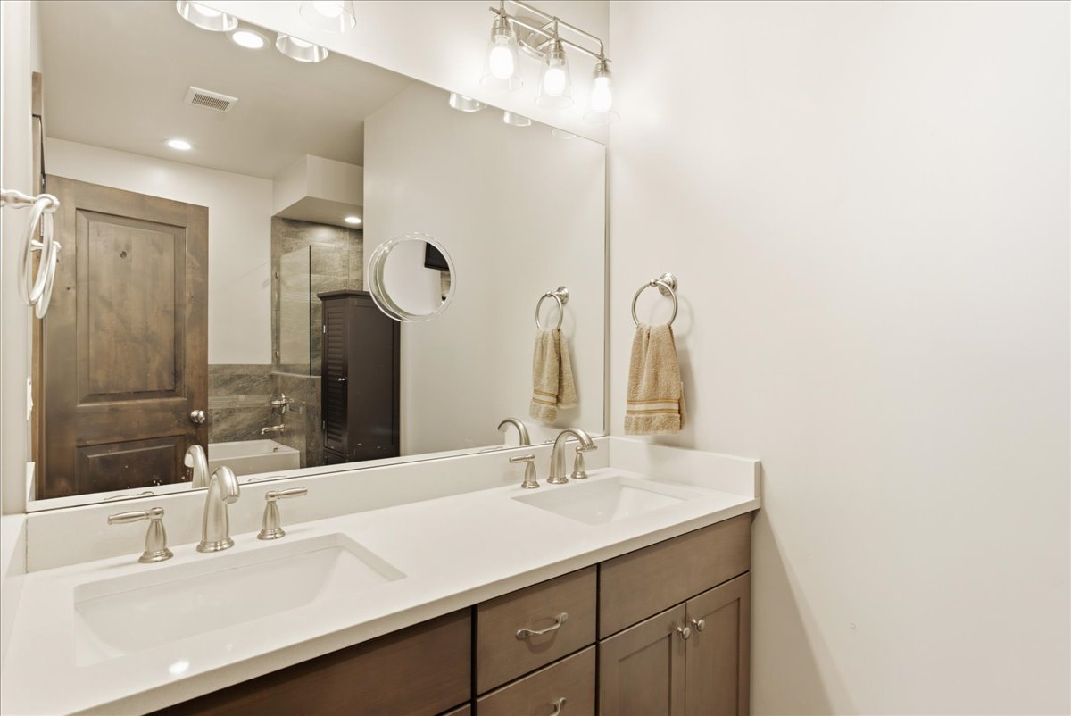 Dual vanity with integrated rectangular sinks and brushed nickel faucets, set in a light-toned countertop