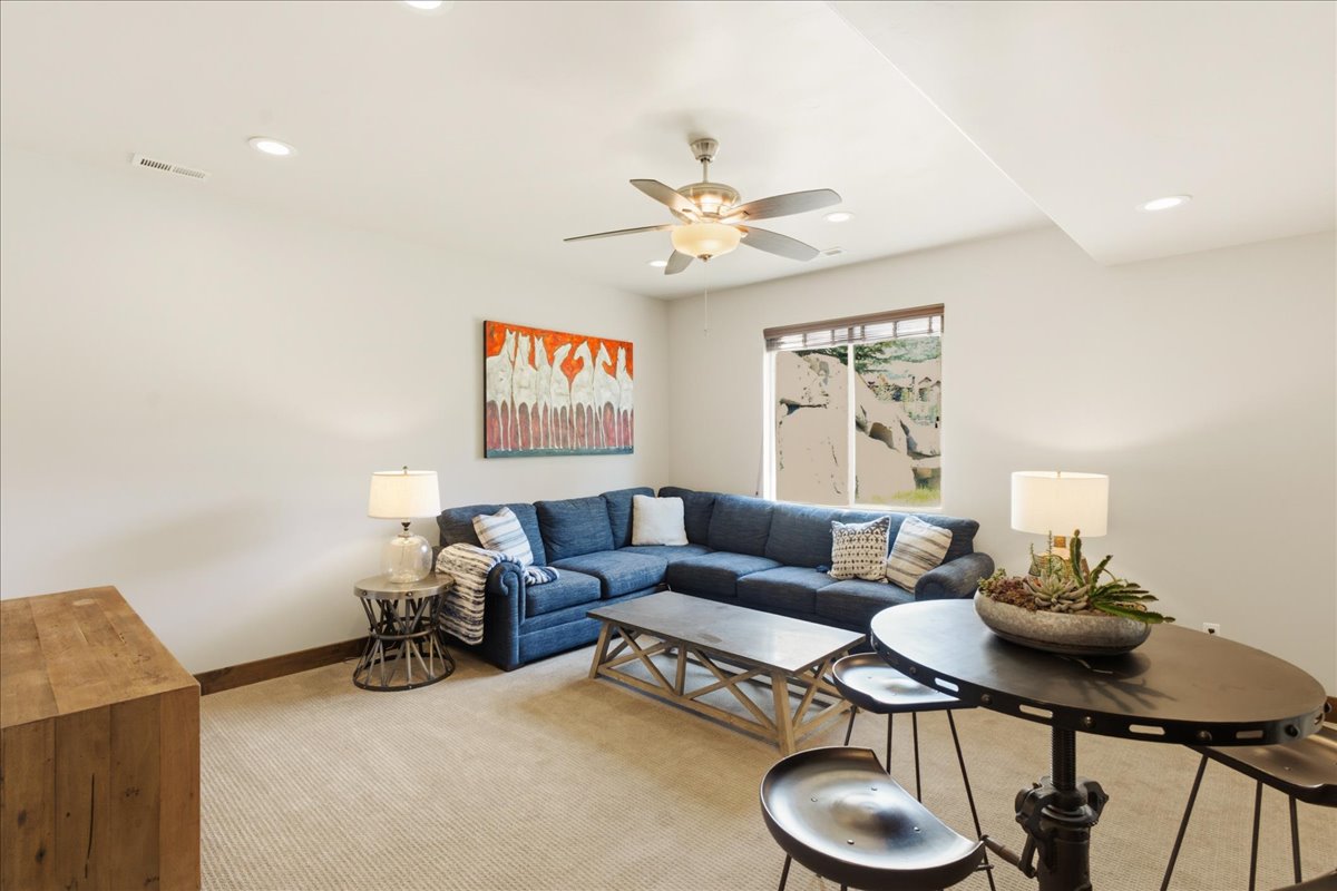 Recessed lighting illuminates this versatile space featuring light-toned carpet flooring