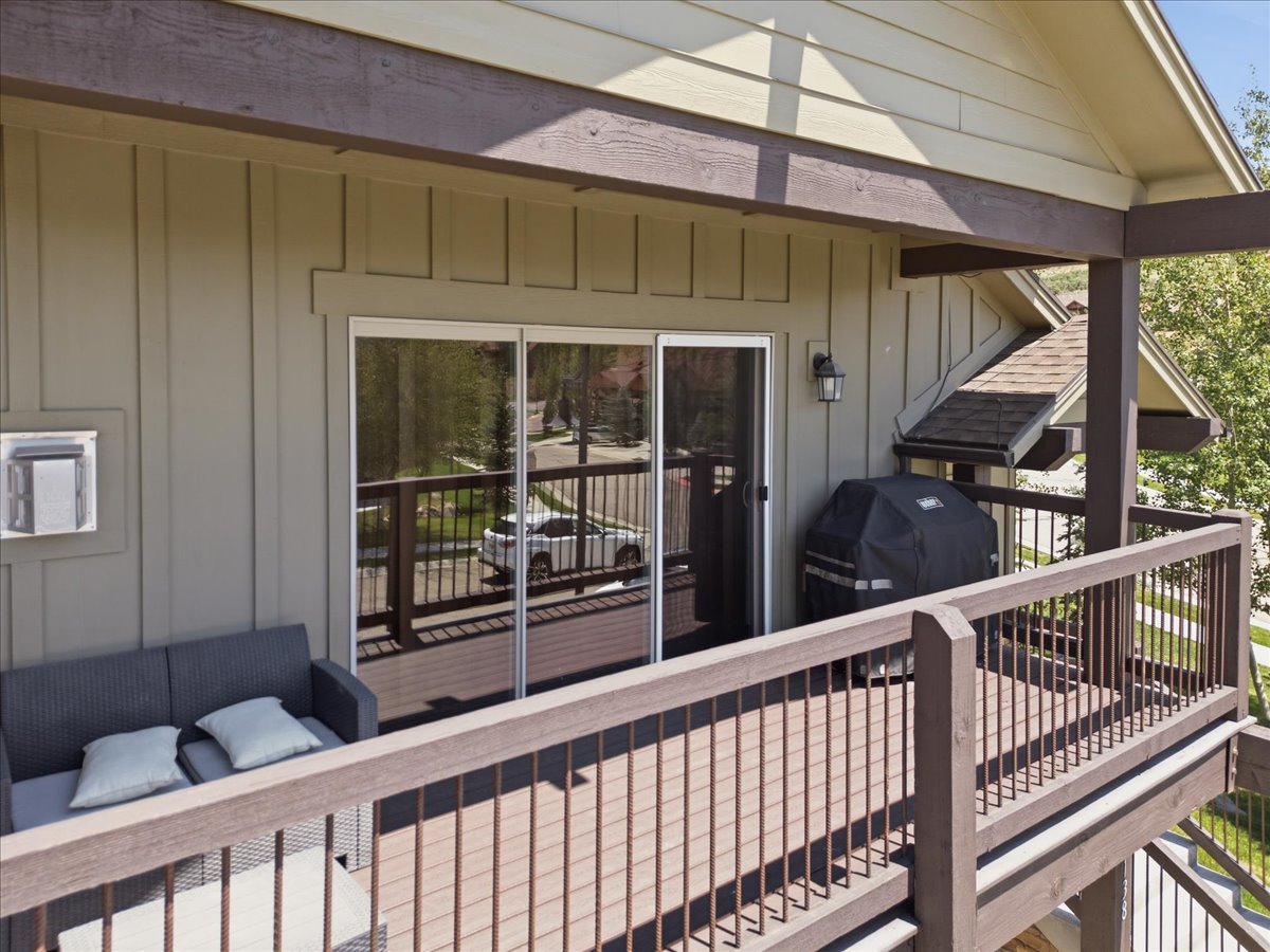 Expansive outdoor deck featuring wood-finish flooring and a full-height railing