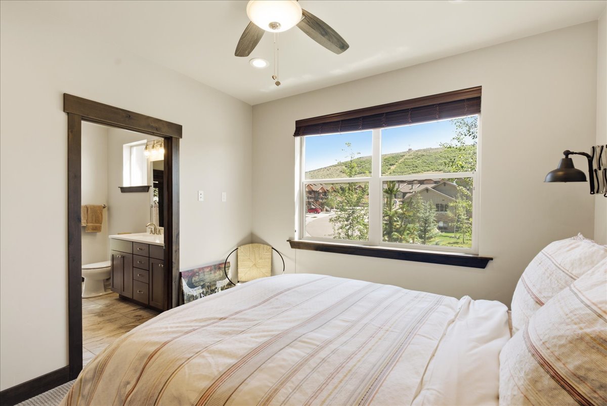 Bright bedroom featuring a ceiling fan, recessed lighting, and a large window with white framing