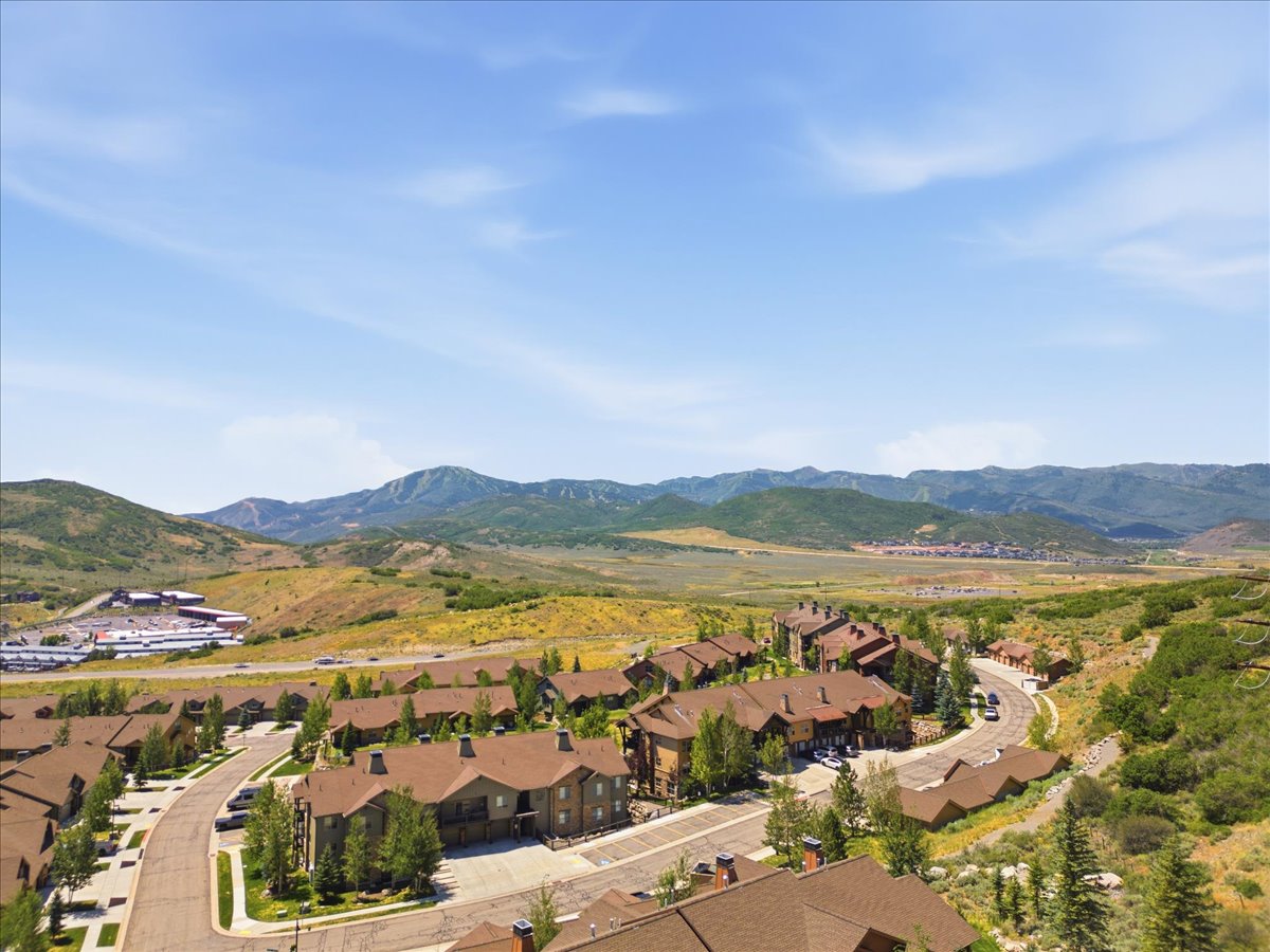 Expansive mountain landscape featuring residential properties with brown roofs and natural wood-tone siding