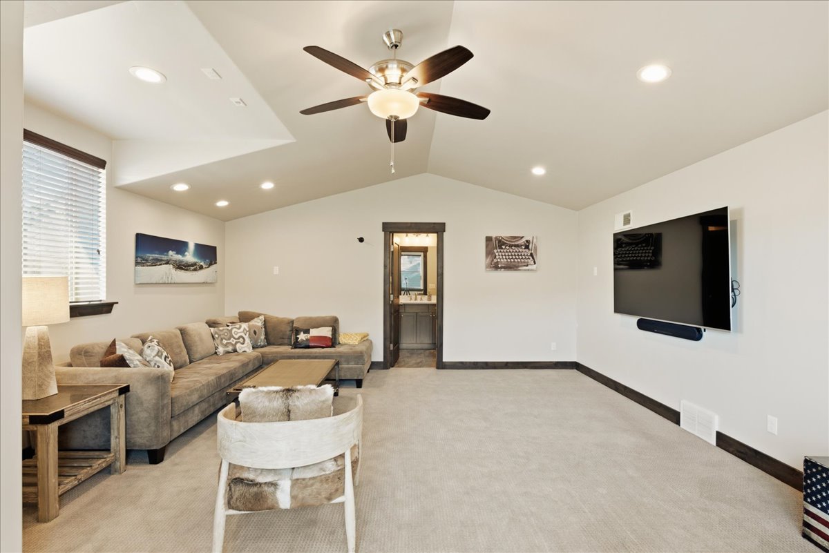 Carpeted room featuring a vaulted ceiling with recessed lighting and a ceiling fan