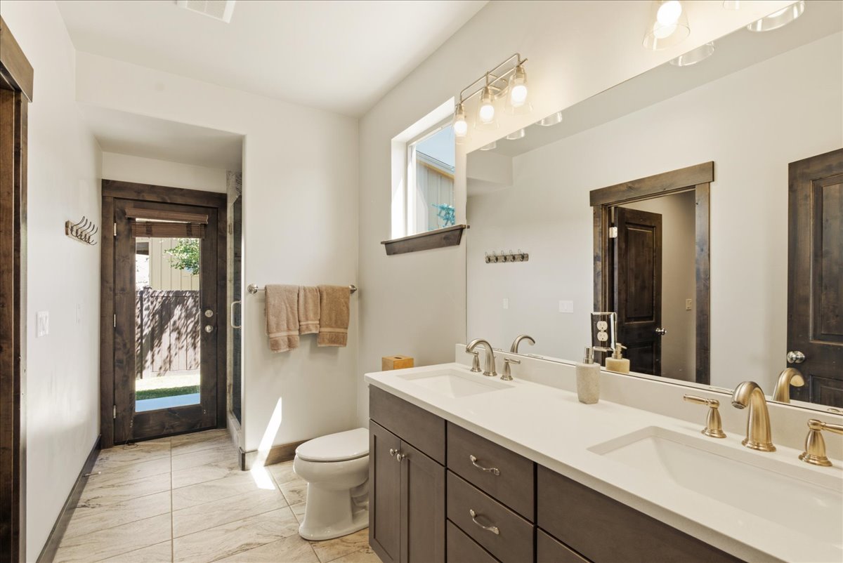 Dual vanity with white countertops, undermount sinks, and mixed-finish faucets