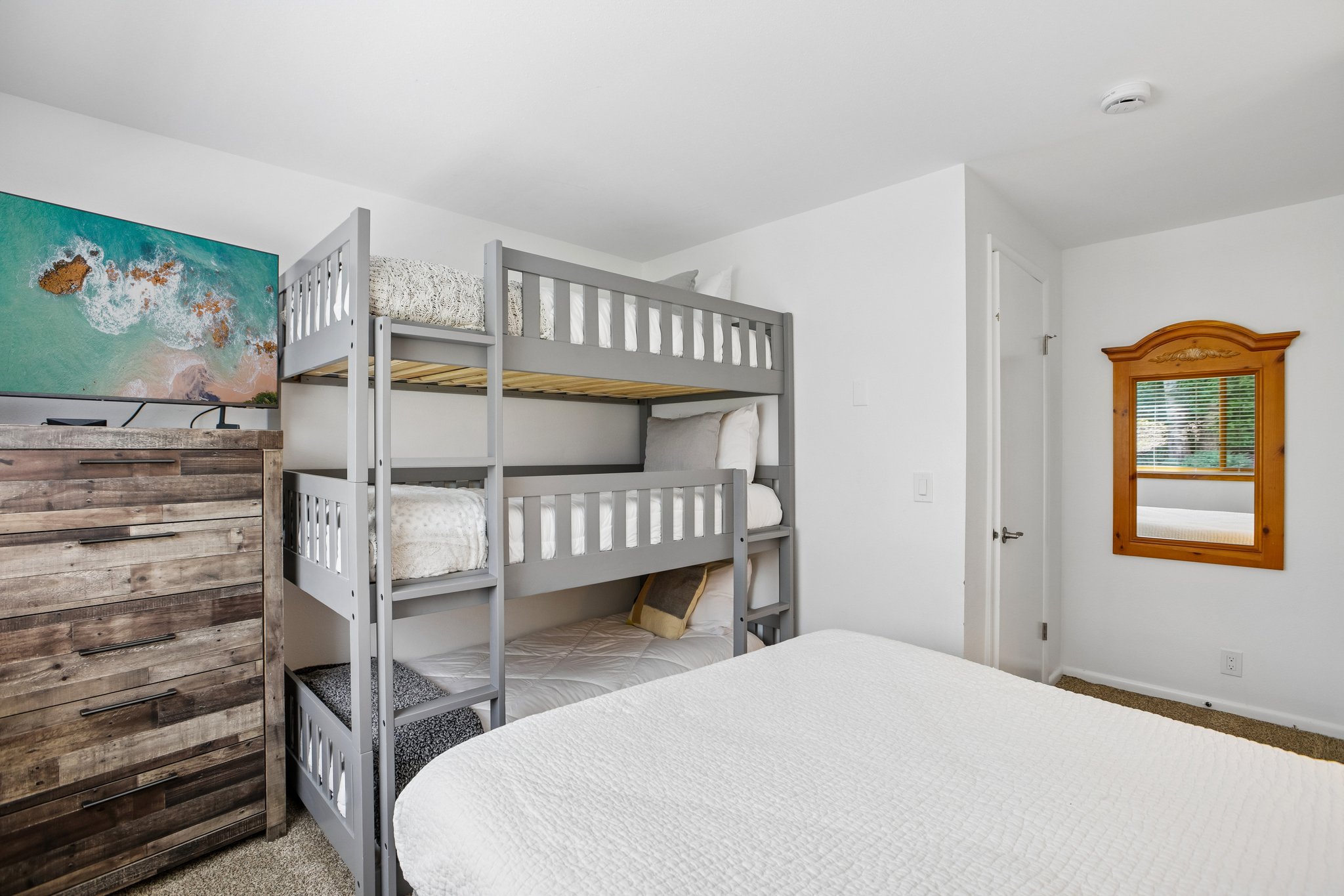 Bedroom featuring a built-in bunk bed system, light gray wood-finish frames, and a lower trundle bed