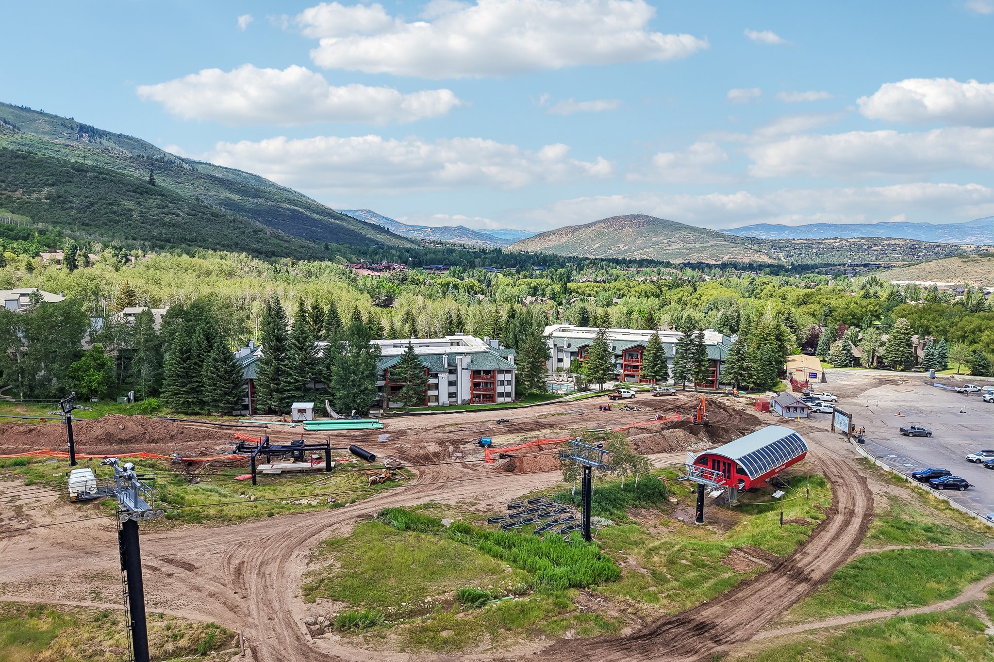 Expansive mountain landscape featuring a ski lift station and multiple residential buildings