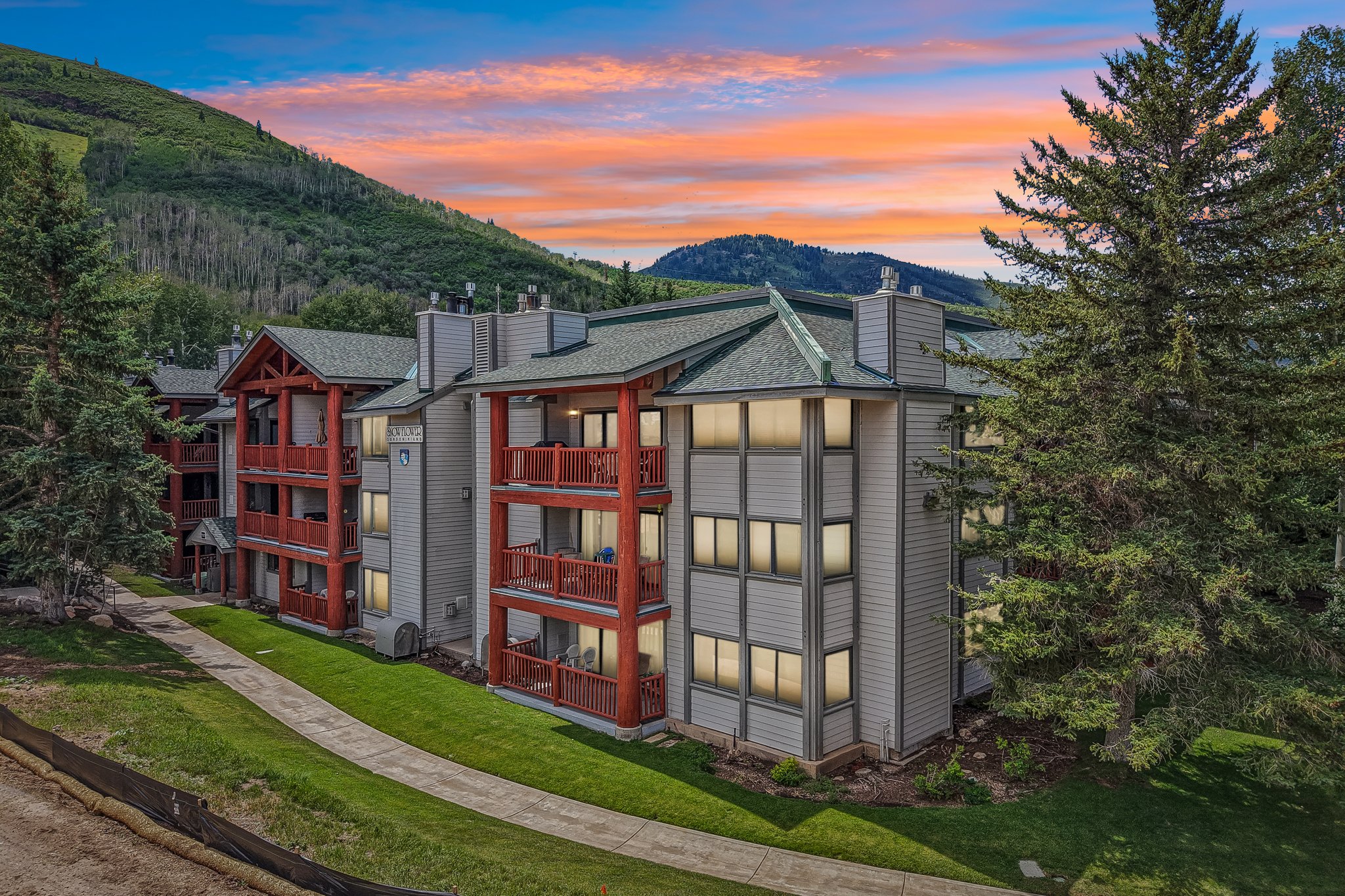 Multi-story residential building with wood-finish balconies and light-colored siding