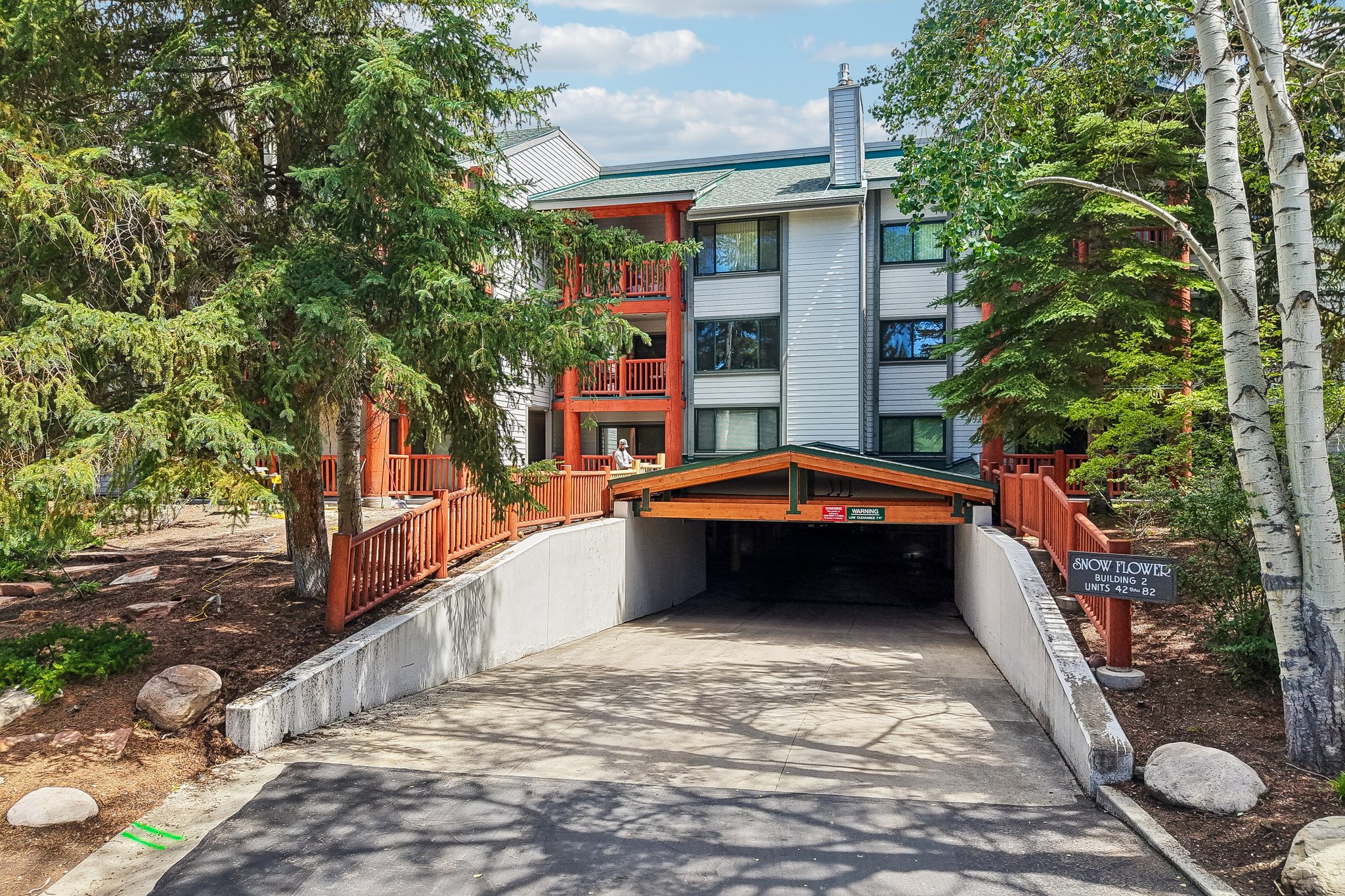 Covered parking entrance with an overhead timber facade