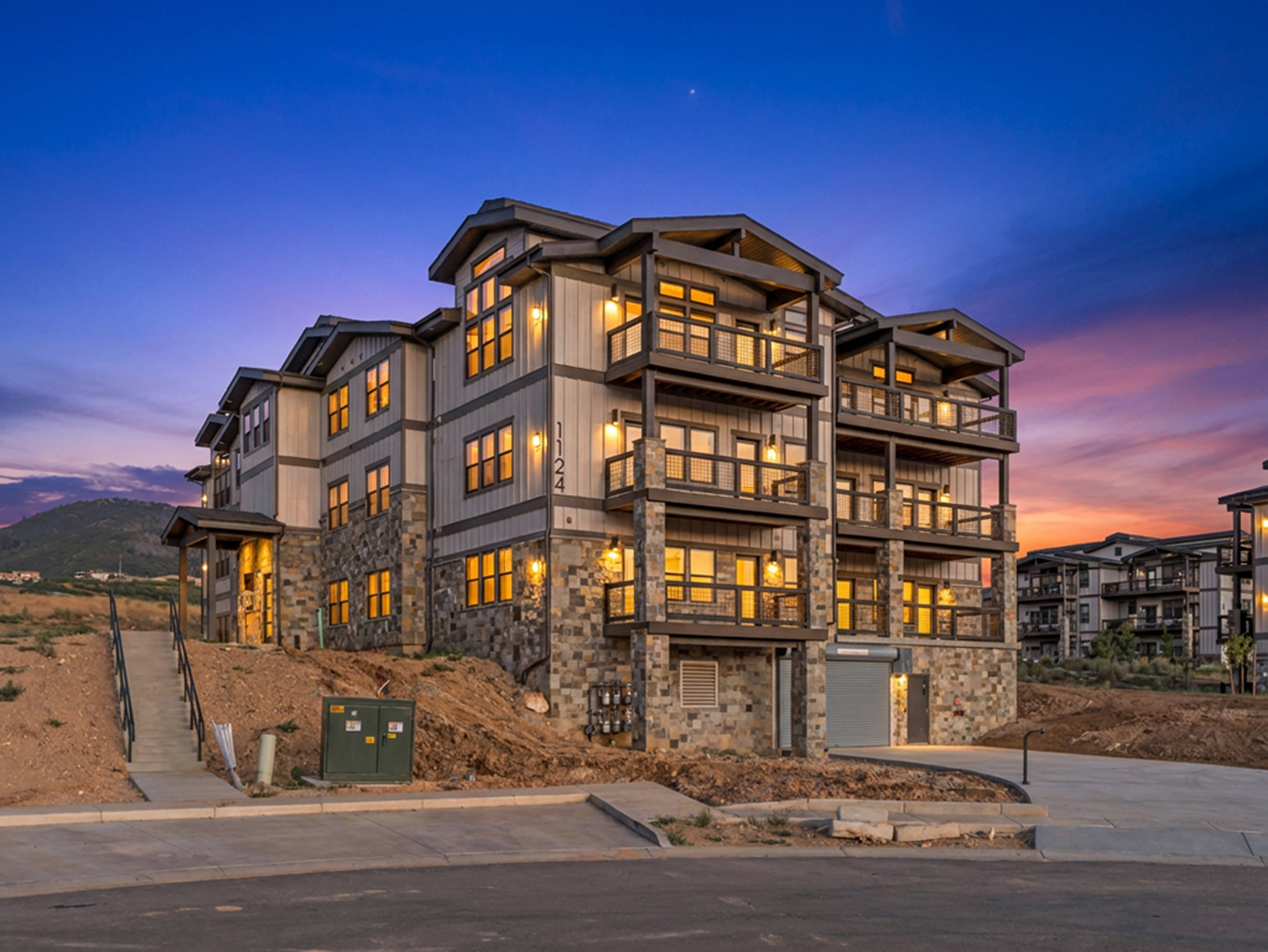 Multi-story building featuring stacked stone and vertical siding