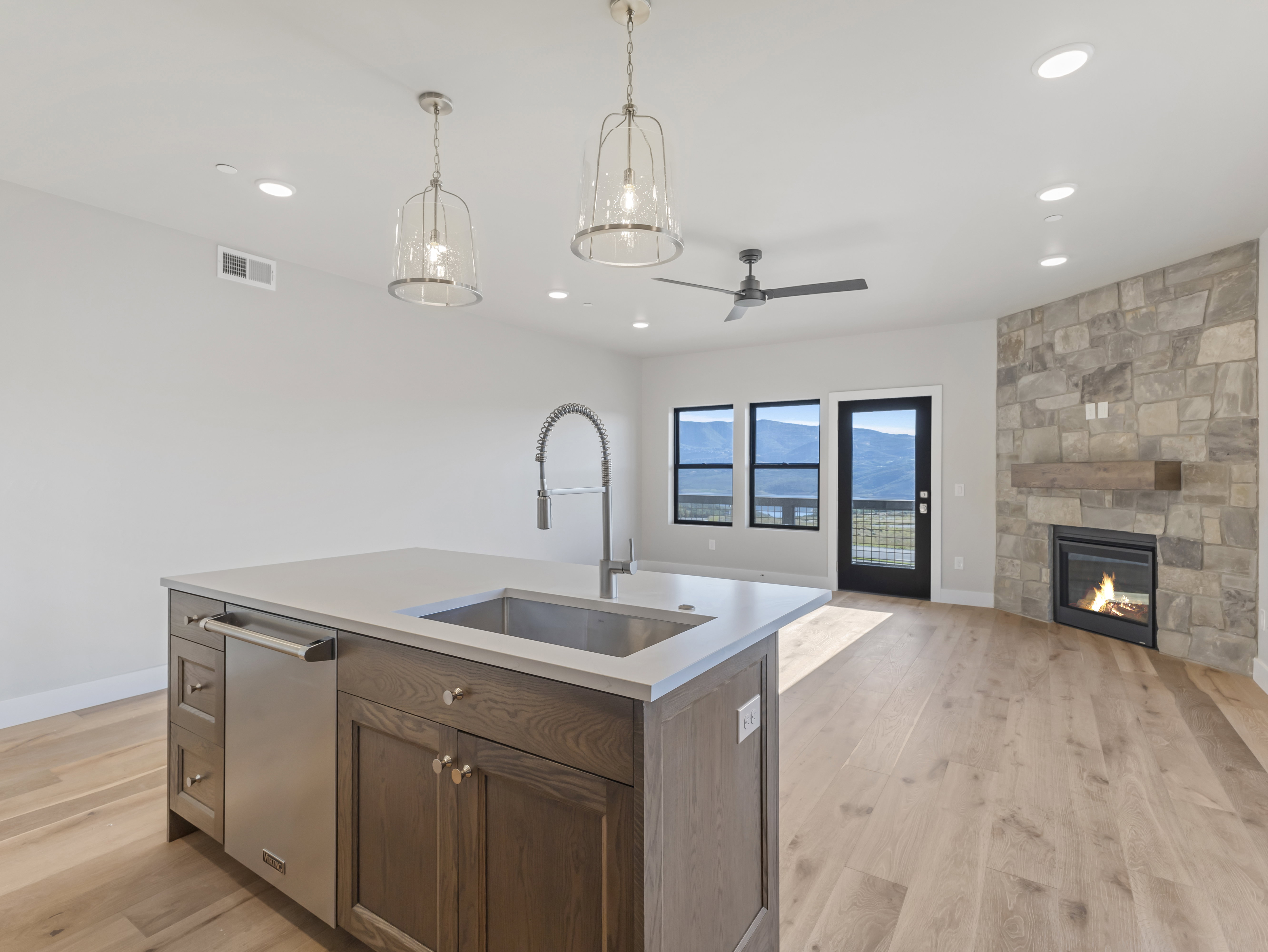 Kitchen island with a built-in stainless steel dishwasher, undermount sink, and gooseneck faucet