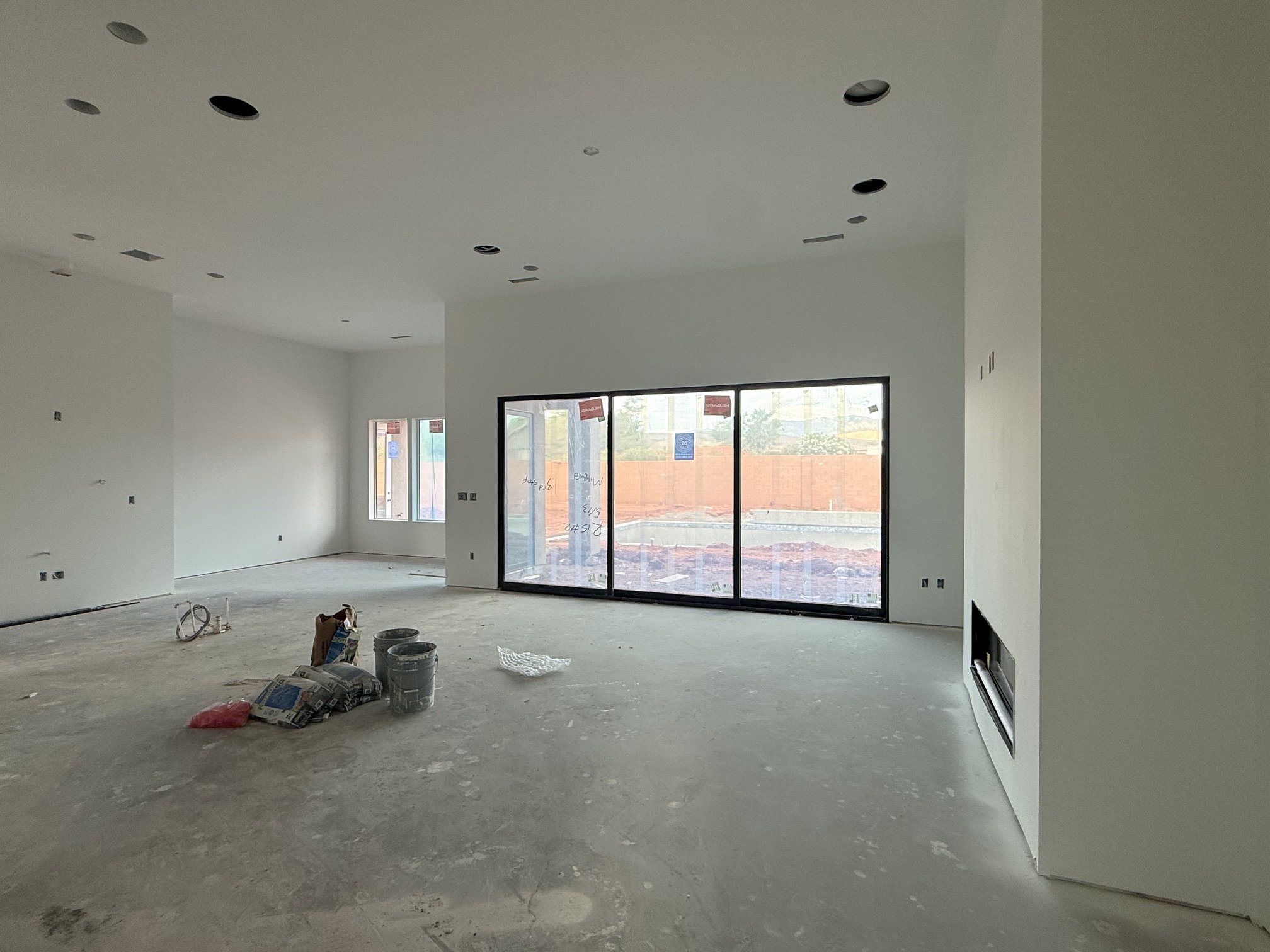 Spacious interior with large sliding glass doors, multiple recessed ceiling lights, and a built-in fireplace