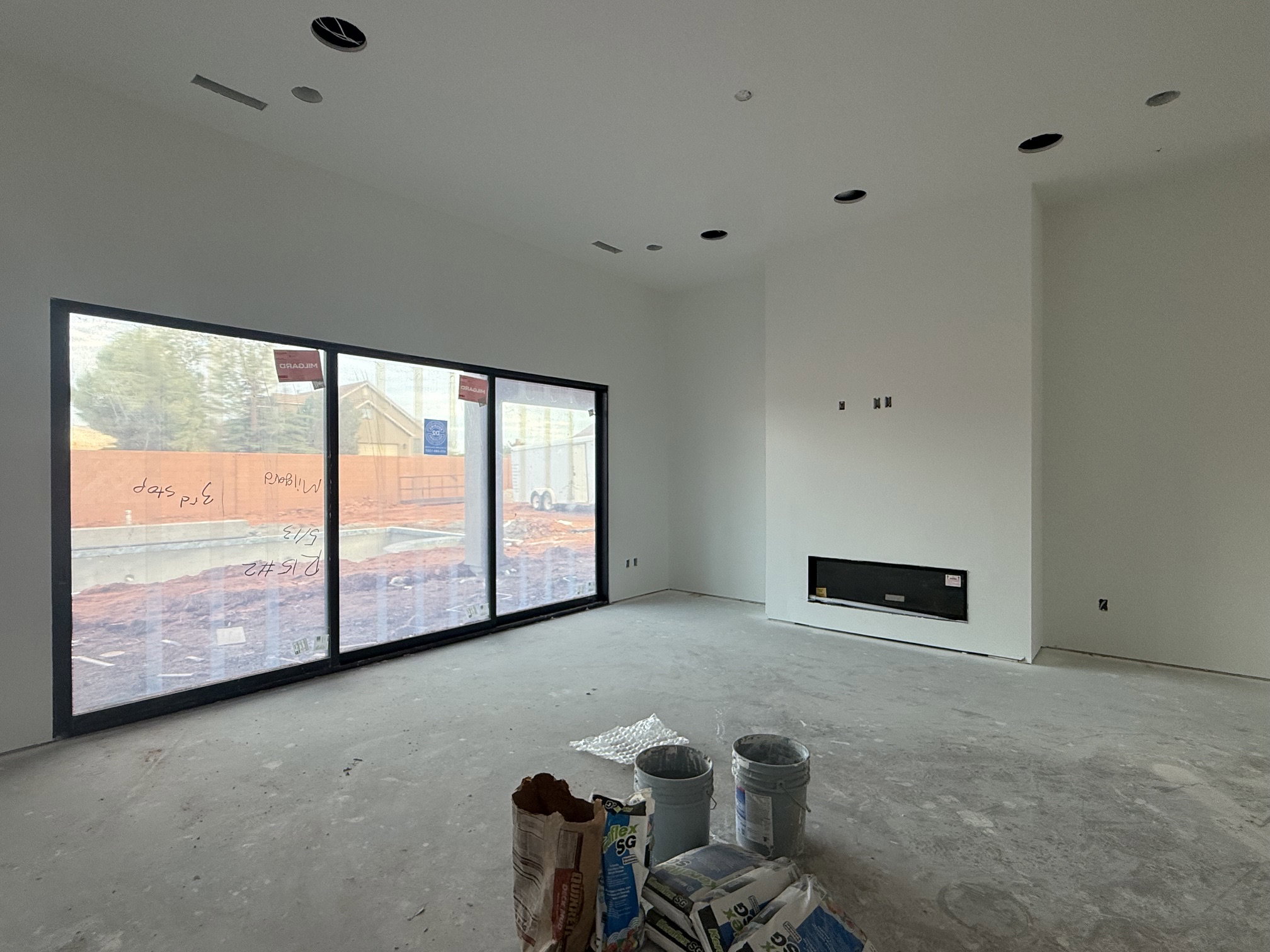 Spacious room featuring a wide sliding glass door system, a contemporary built-in fireplace, and recessed ceiling lighting
