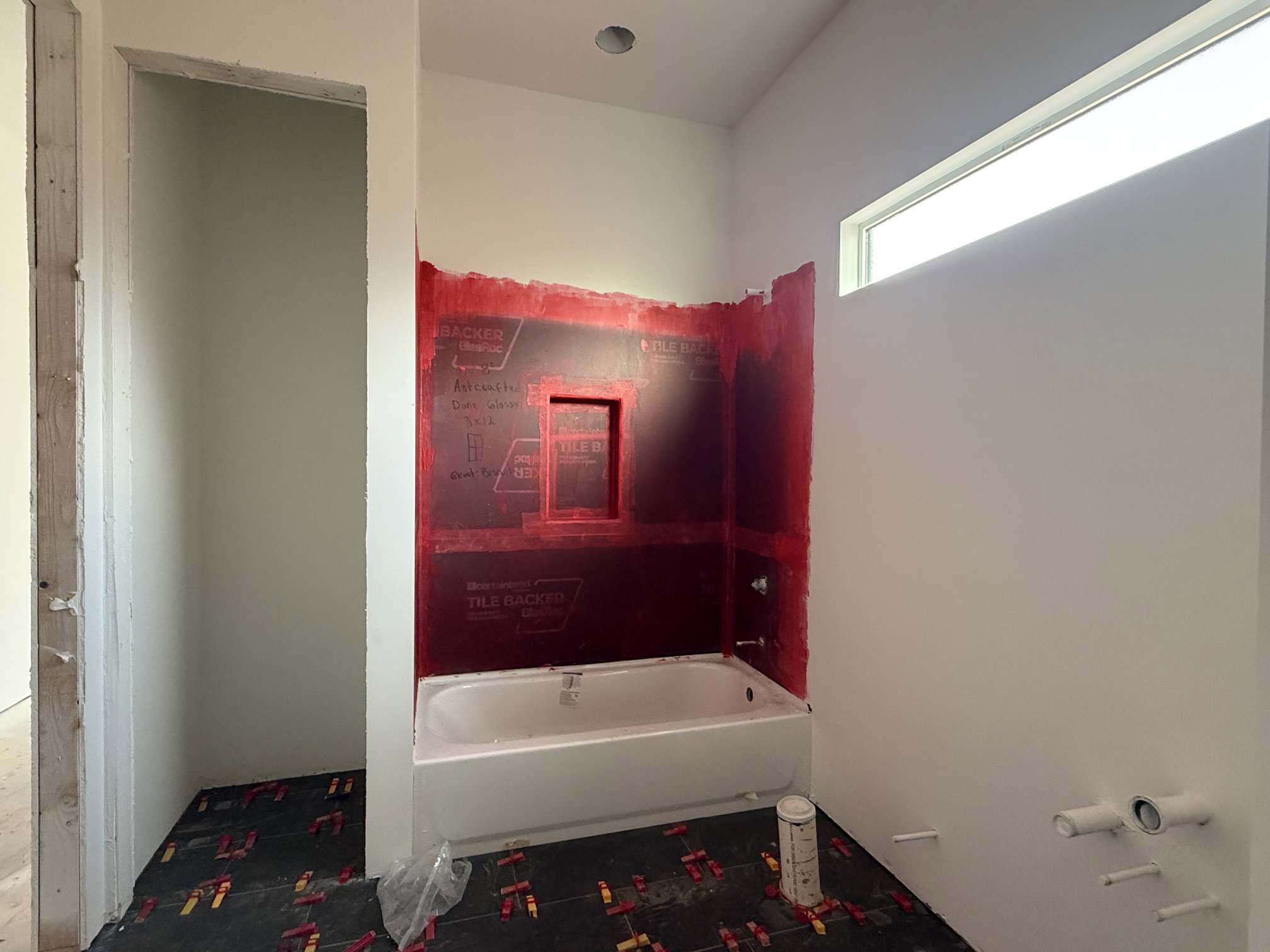 Bathroom featuring a built-in tub with shower plumbing, a recessed niche, and a horizontal transom window