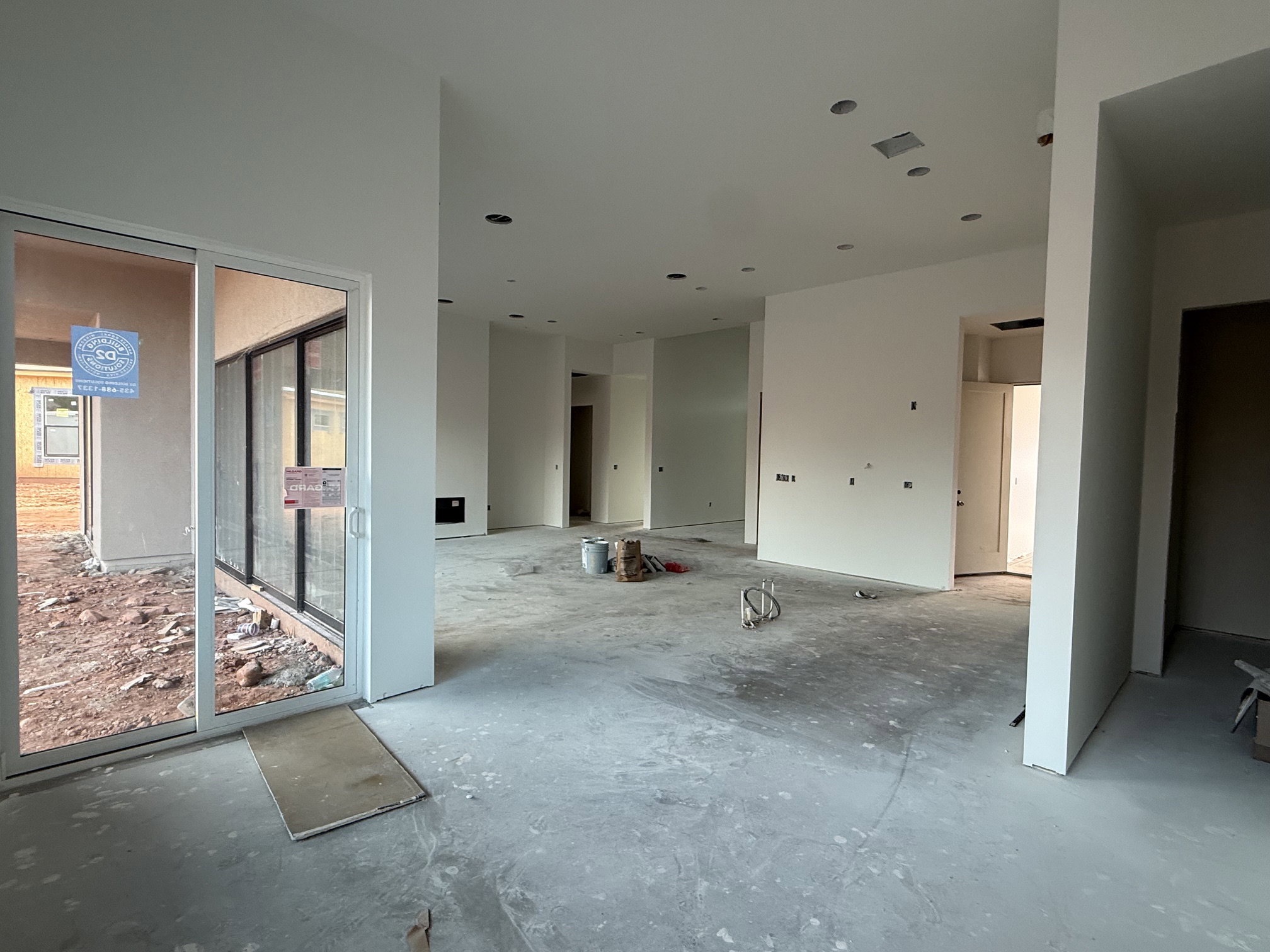 Open-concept interior featuring white walls, concrete flooring, and recessed lighting