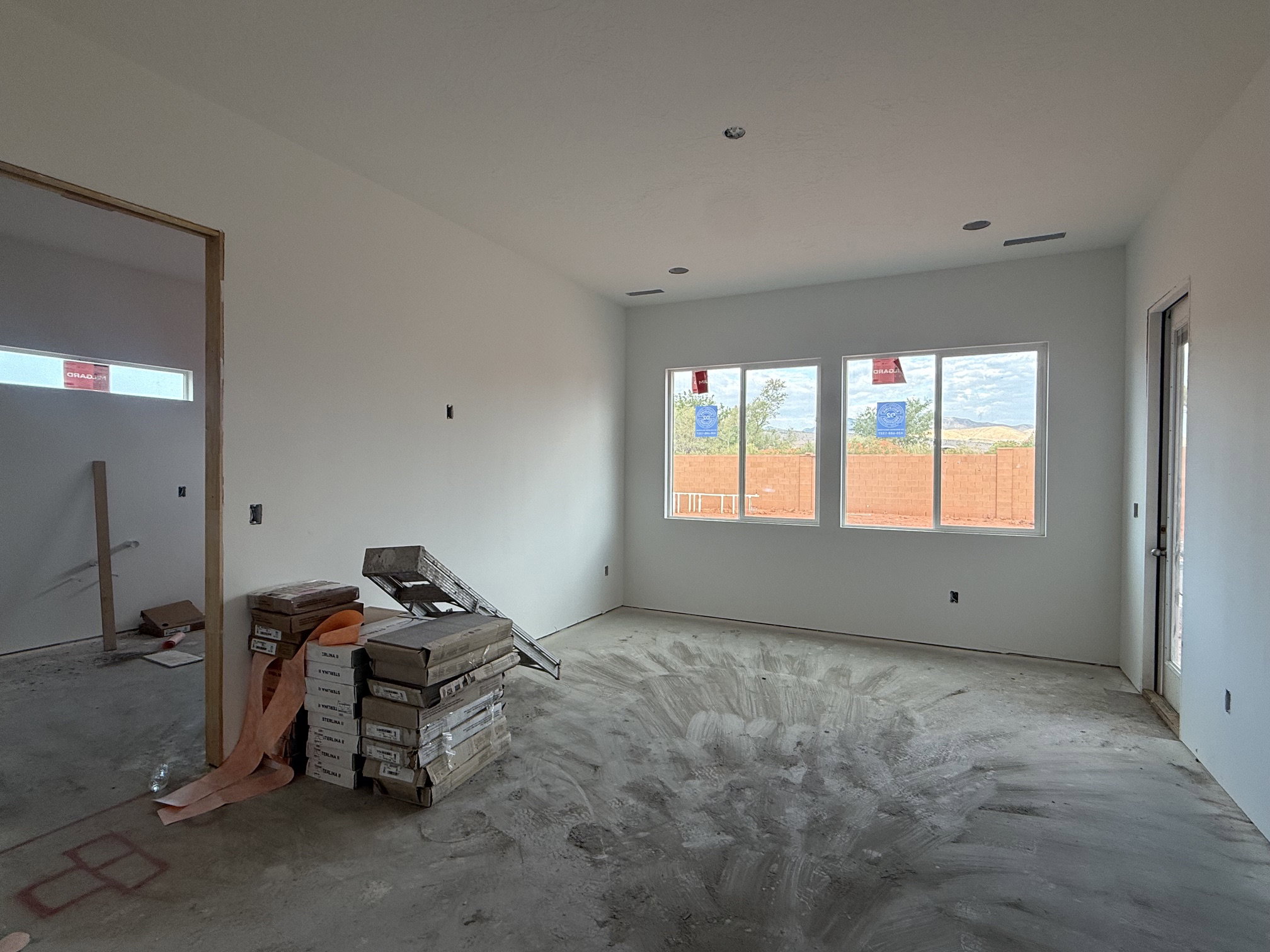 Spacious room featuring multiple windows, a transom window, recessed ceiling lighting, and a glass-paneled exterior door