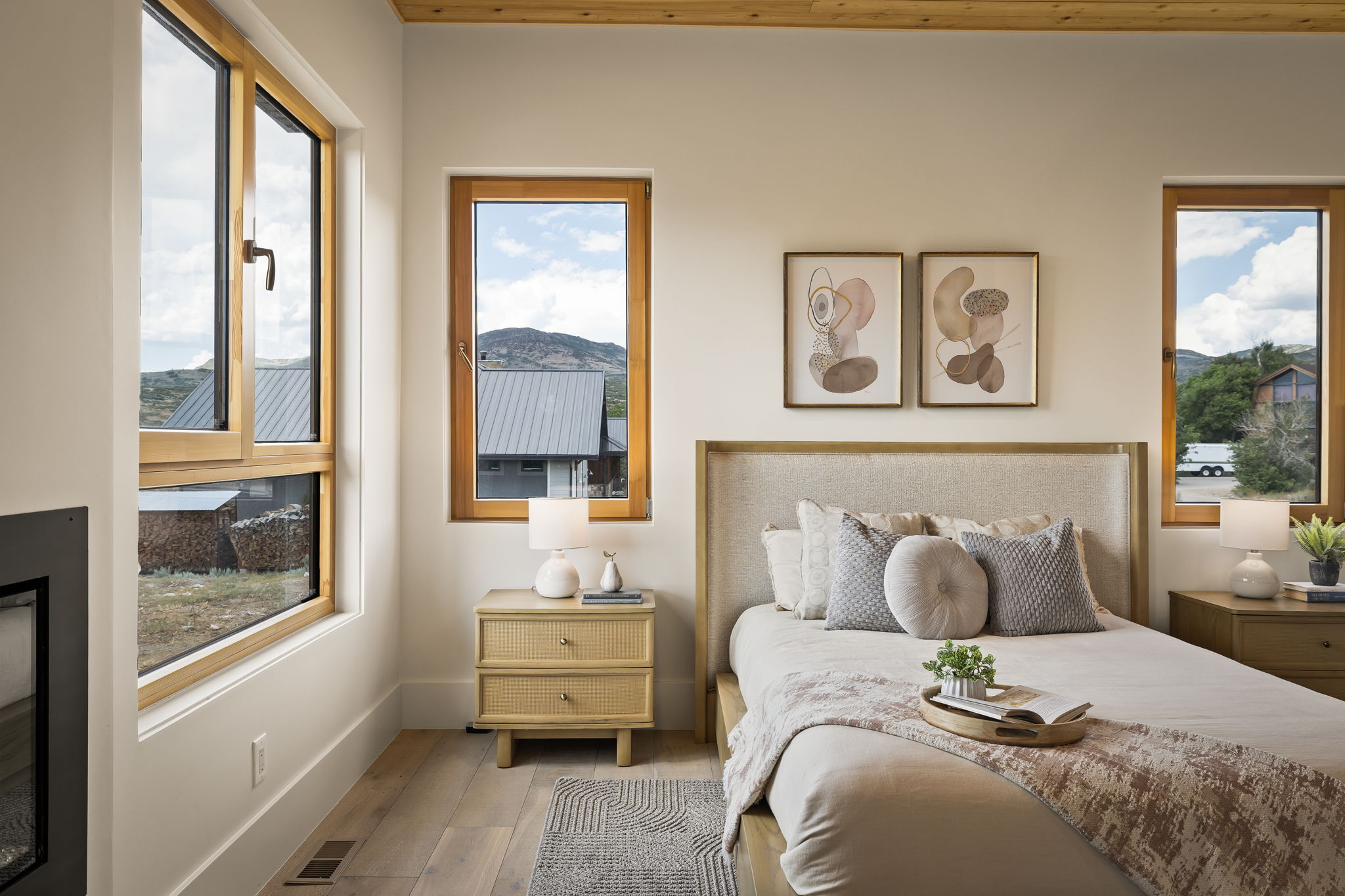 Bright interior featuring light wood-finish flooring and multiple windows with natural wood frames