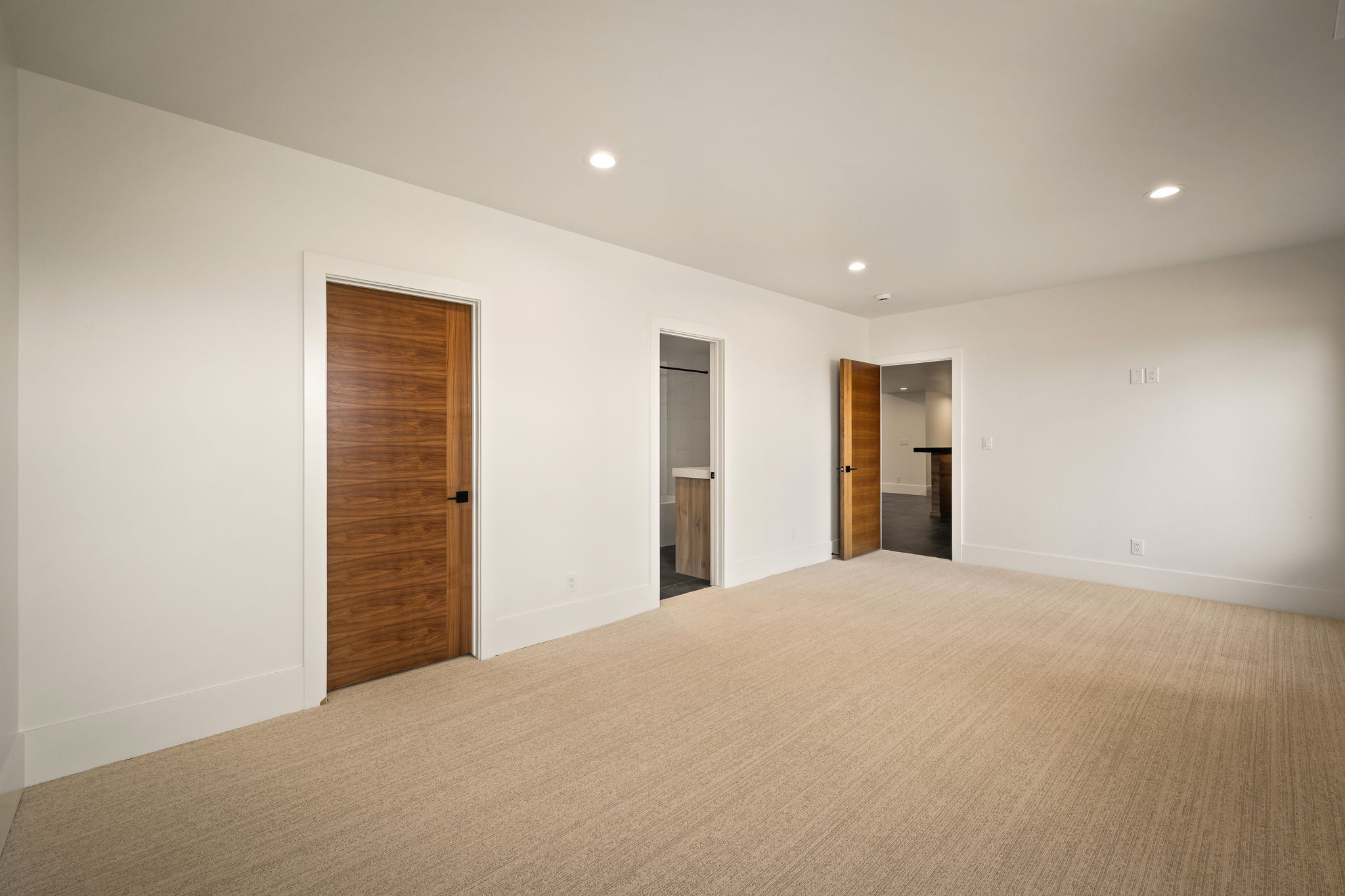 Spacious room with plush carpet flooring and recessed lighting