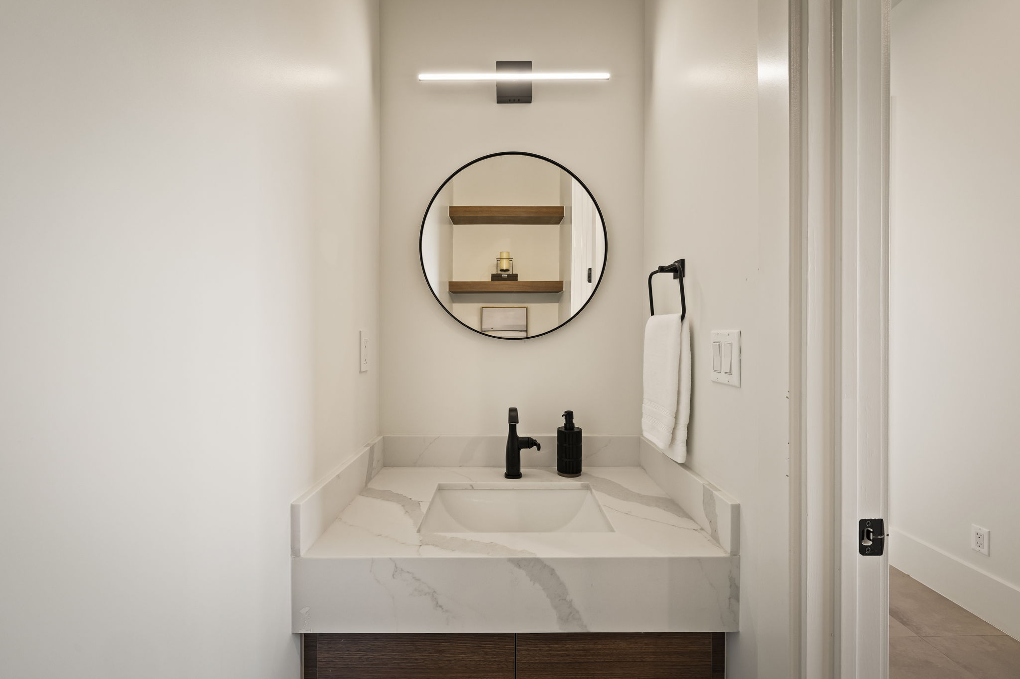 Bathroom vanity featuring a rectangular integrated sink, patterned countertop, and wood-finish cabinetry