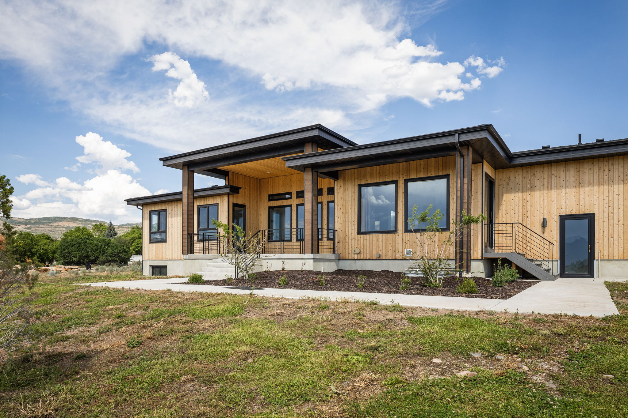 Contemporary home exterior featuring natural wood siding and a flat roofline