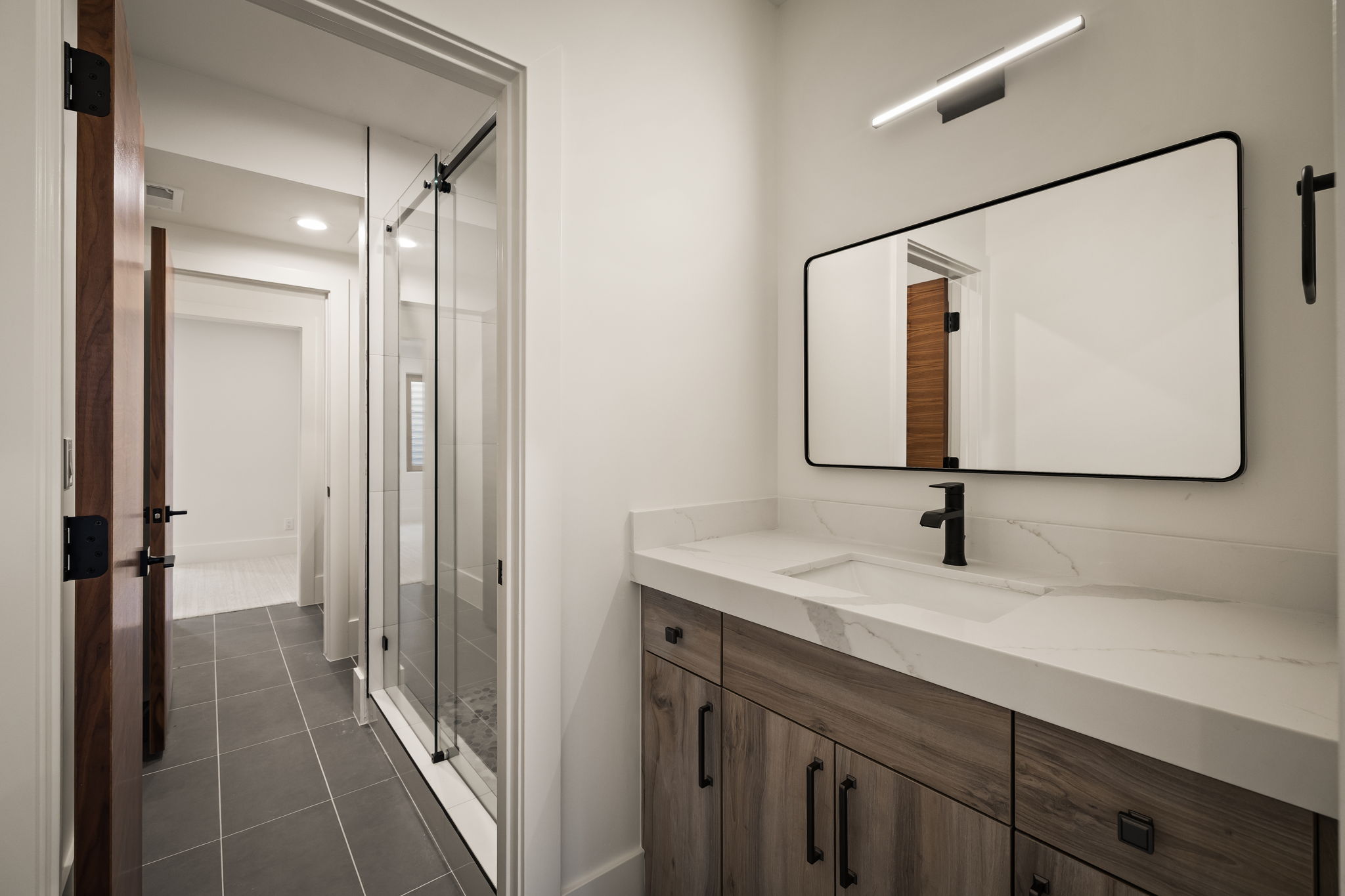 Bathroom featuring a floating wood-finish vanity with an integrated sink and white countertop