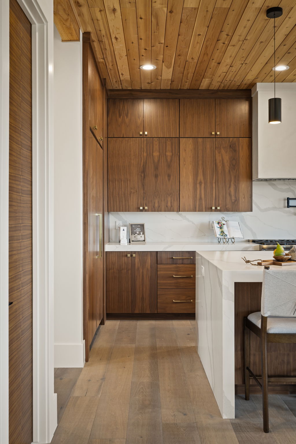 Kitchen featuring extensive wood cabinetry, light wood-finish flooring, and a wood plank ceiling