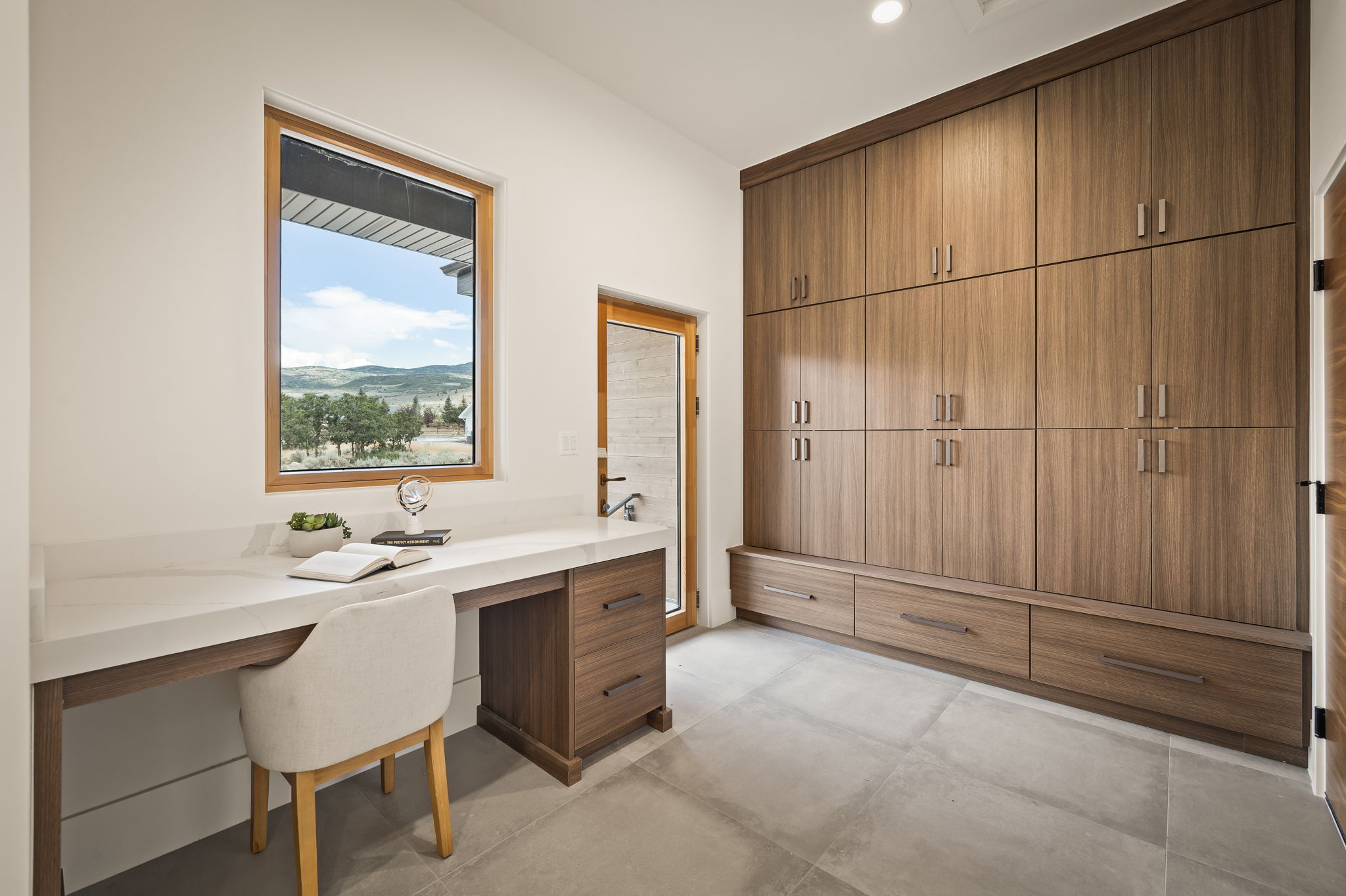 Built-in desk featuring a white countertop and wood-finish cabinetry