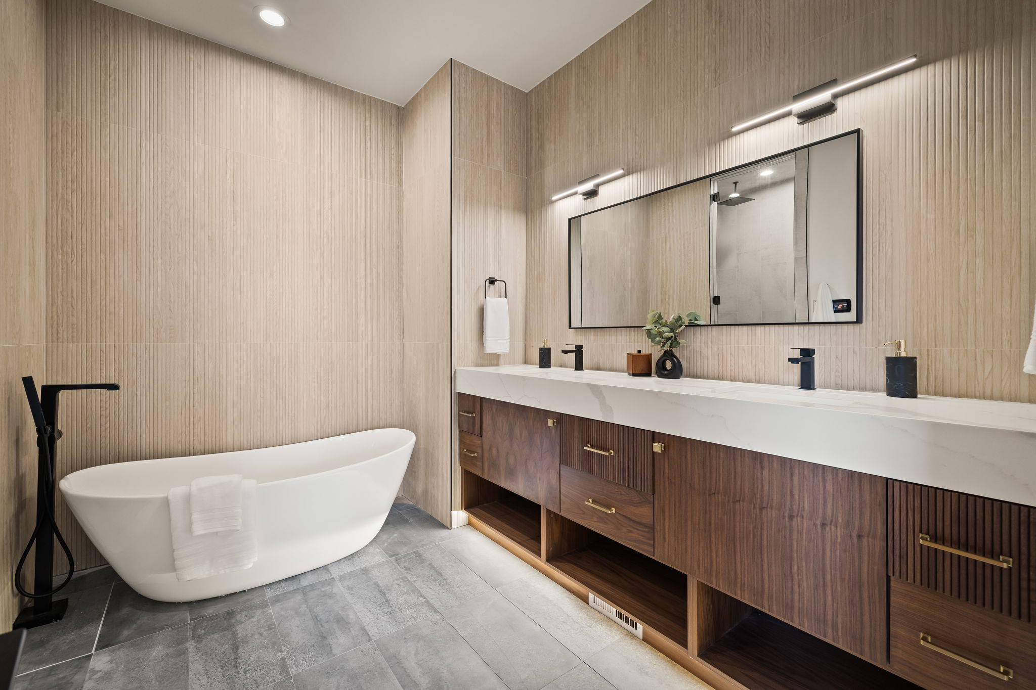 Freestanding soaking tub with floor-mounted matte black faucet