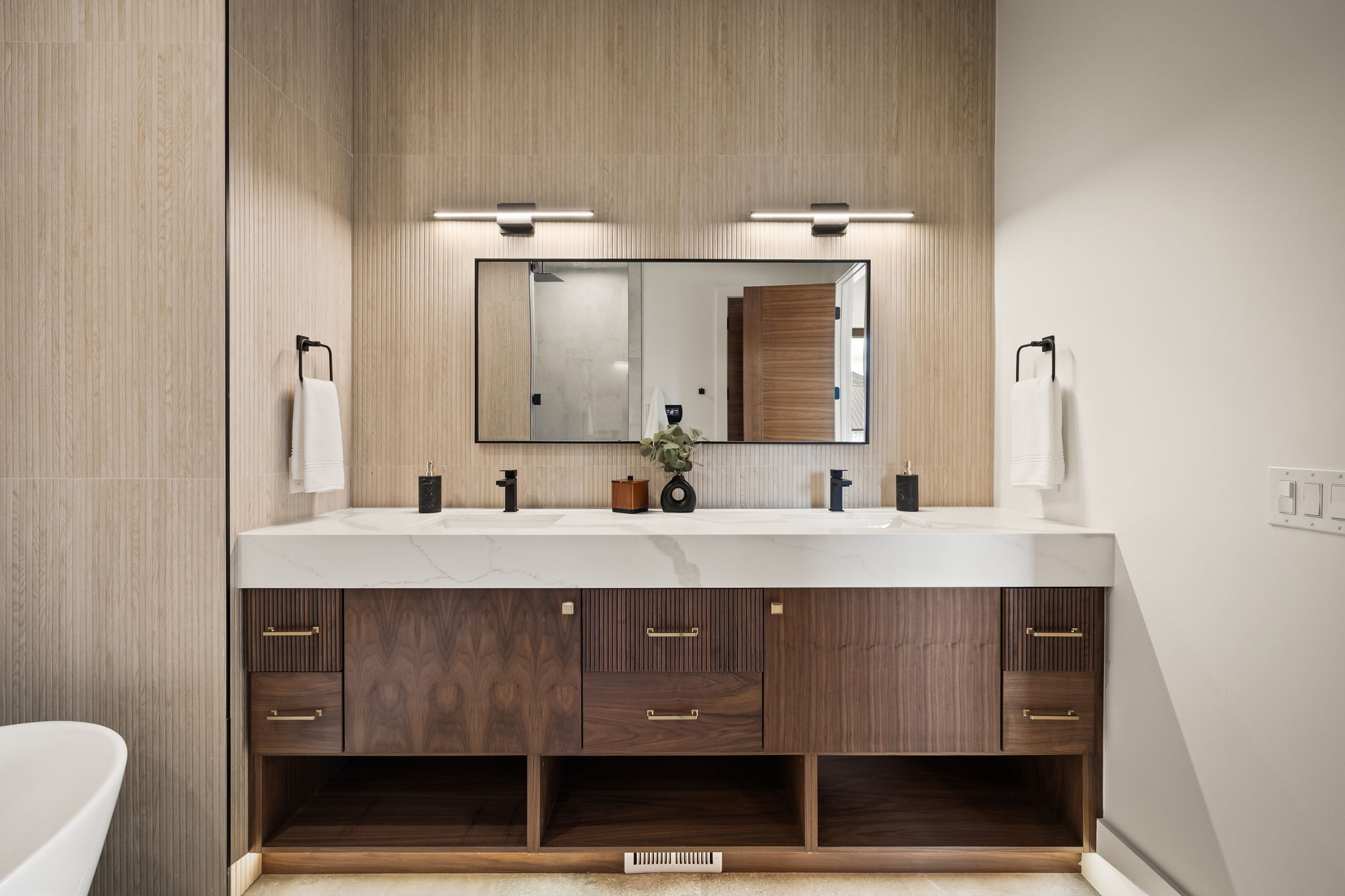 Dual sink vanity with dark wood cabinetry and a light-toned countertop
