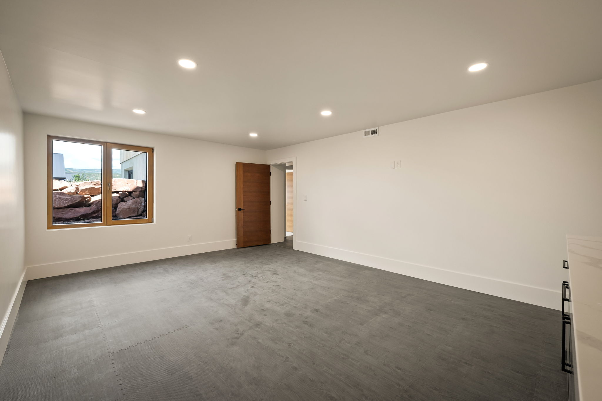 Spacious room with light gray flooring and white walls