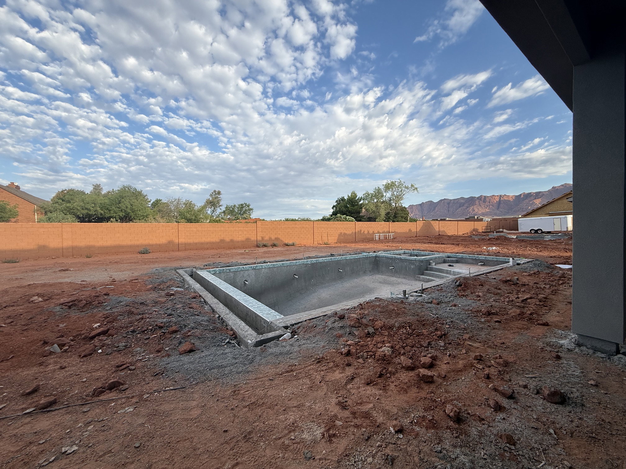 Backyard featuring an in-ground pool structure, integrated spa, and a concrete perimeter