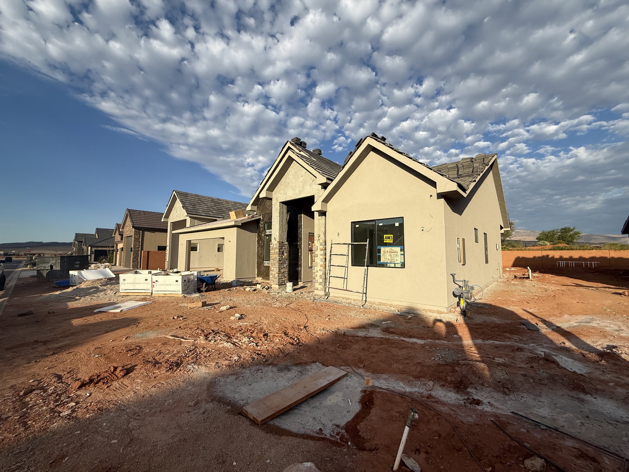 Newly constructed home featuring stucco exterior, stone facade accents, and a shingle roof