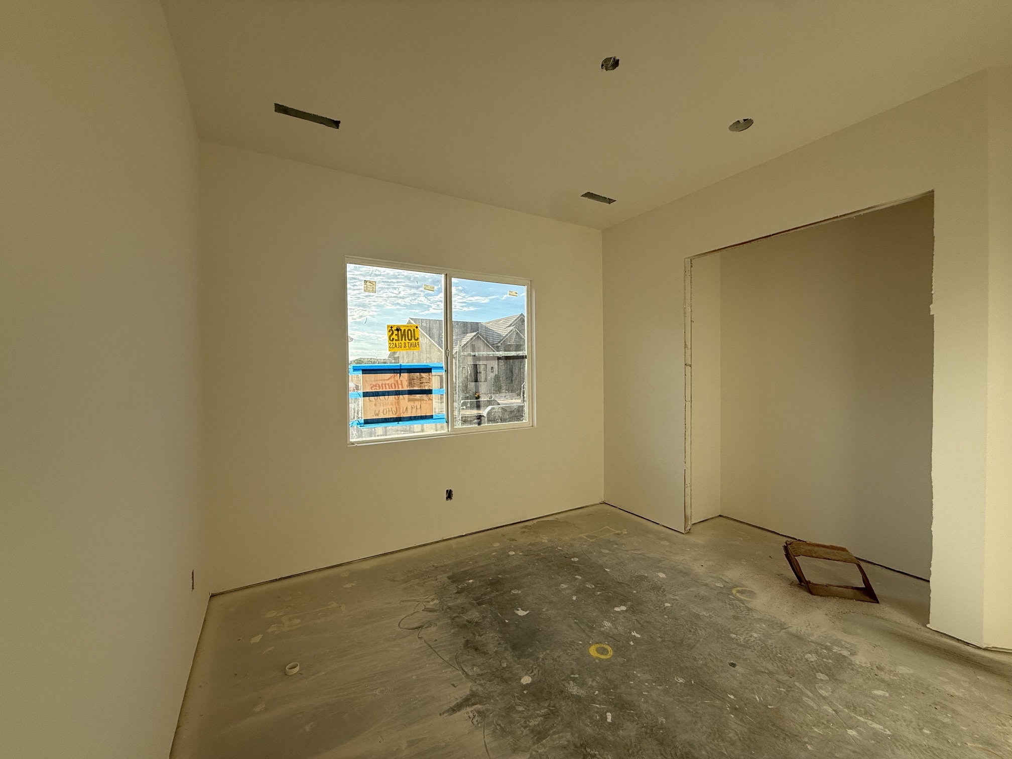 Bright interior space with a window, recessed ceiling lighting, and an open doorway
