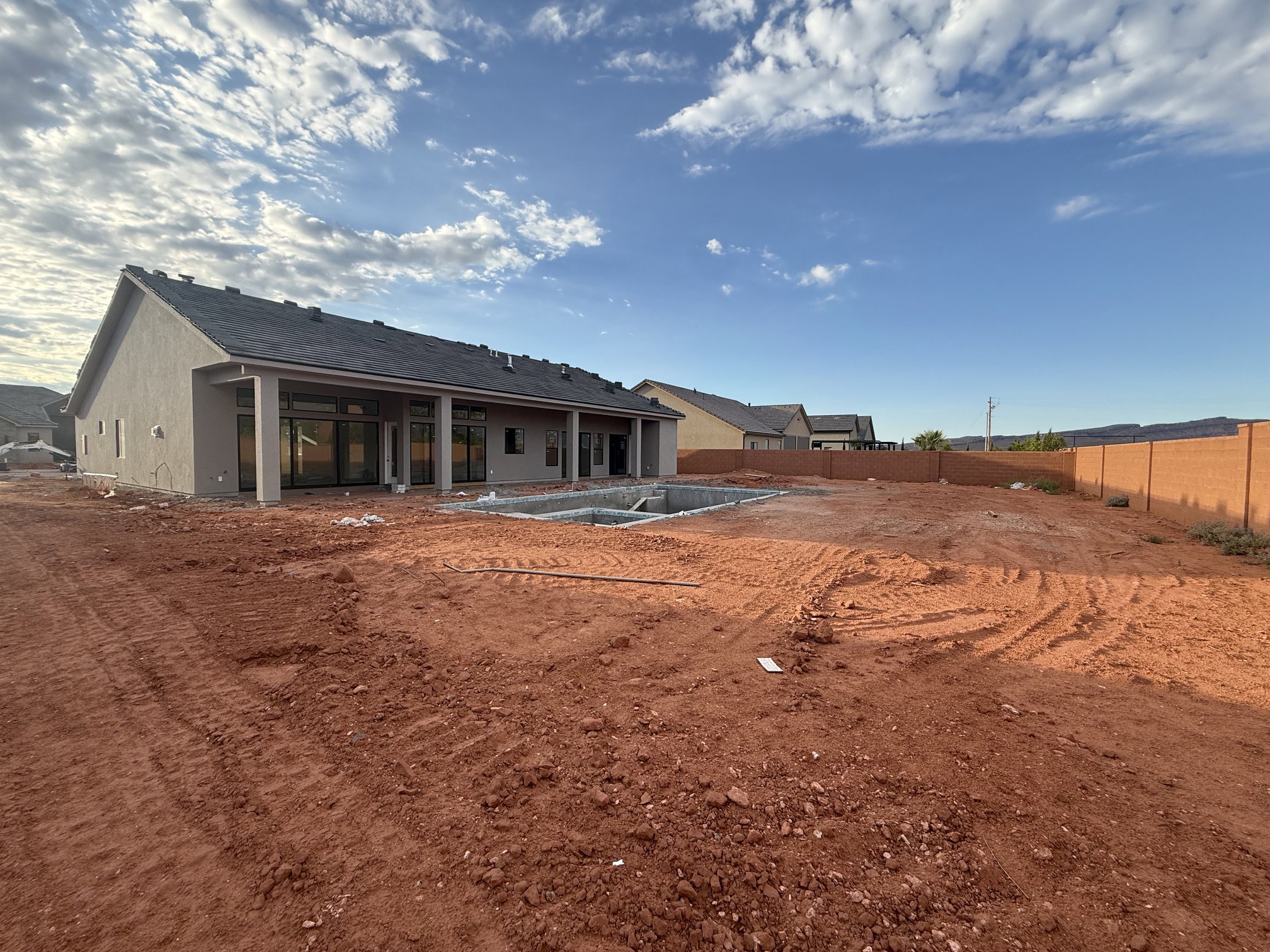 New construction residence featuring a stucco exterior and dark shingle roof