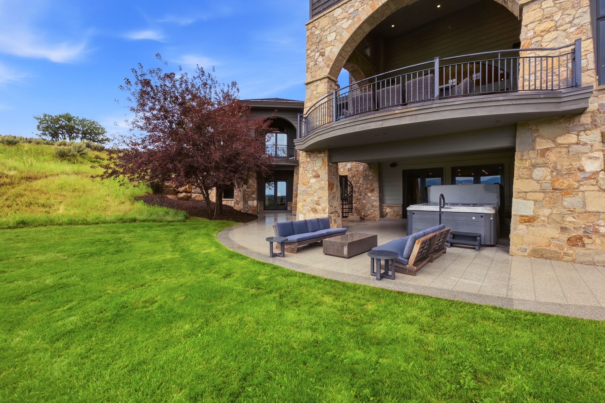 Stone exterior featuring an arched balcony with metal railings