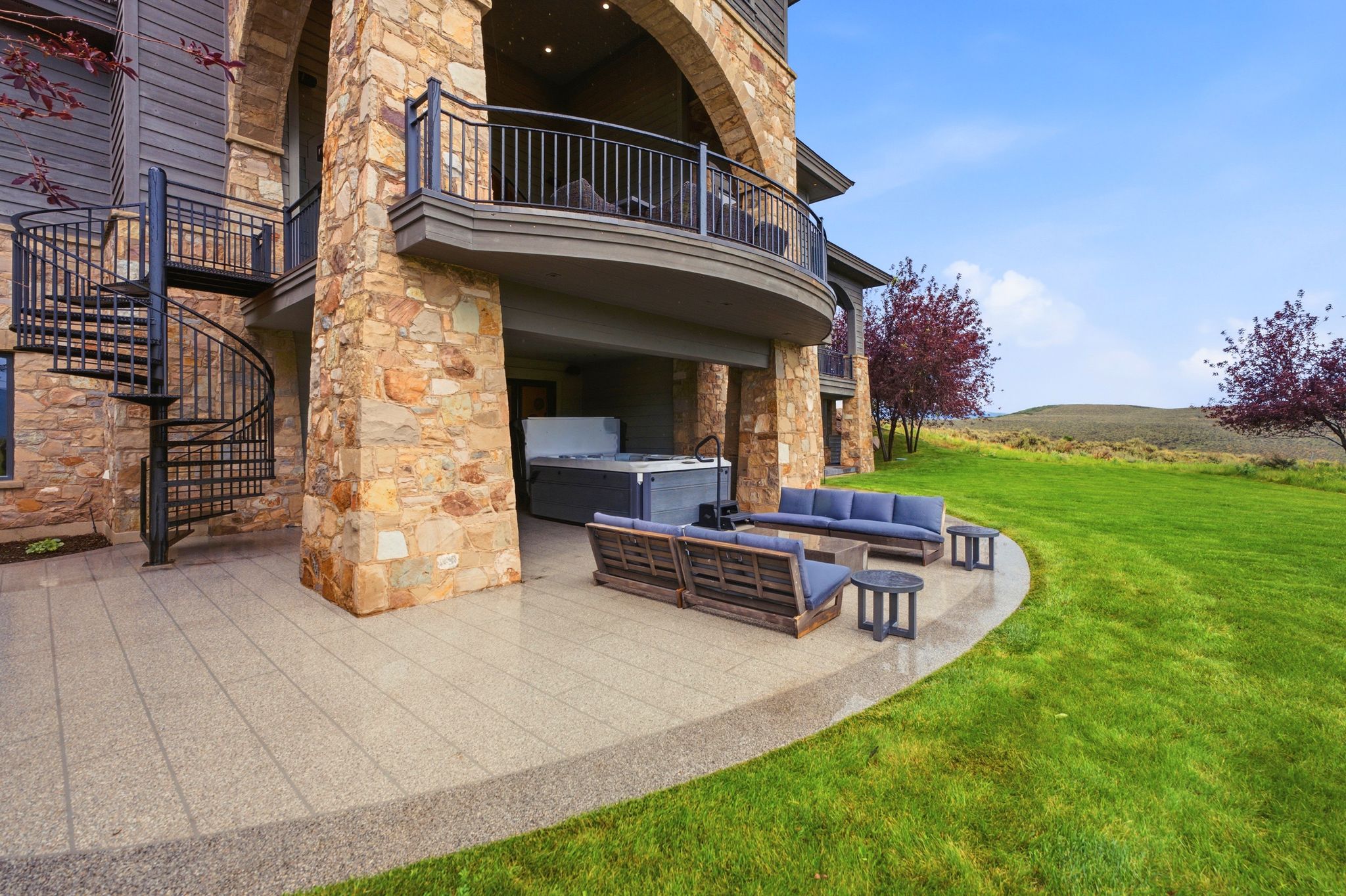 Covered patio with stone columns and a built-in hot tub