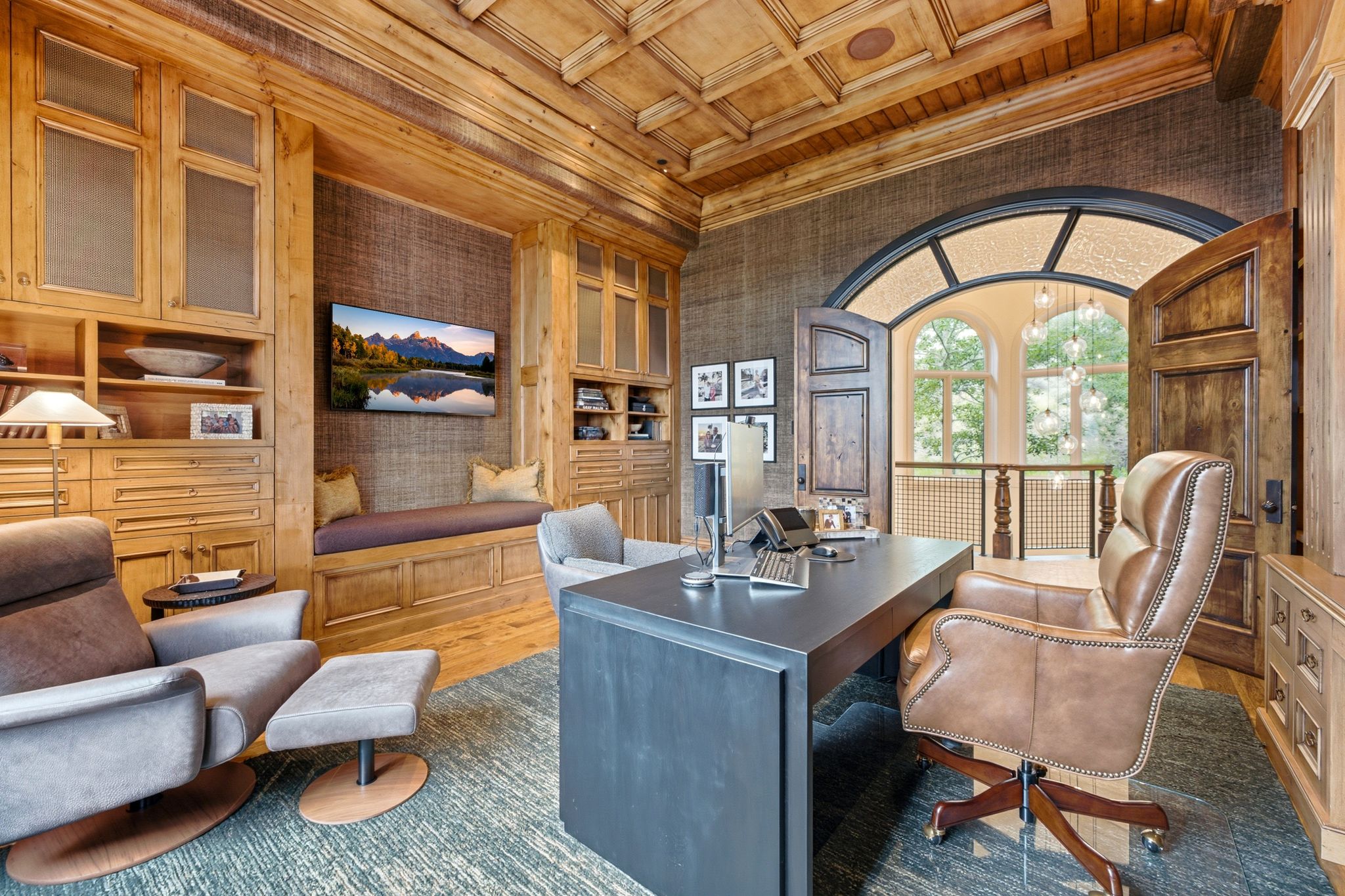 Wood-paneled room featuring extensive built-in cabinetry, coffered ceiling, and textured wall coverings